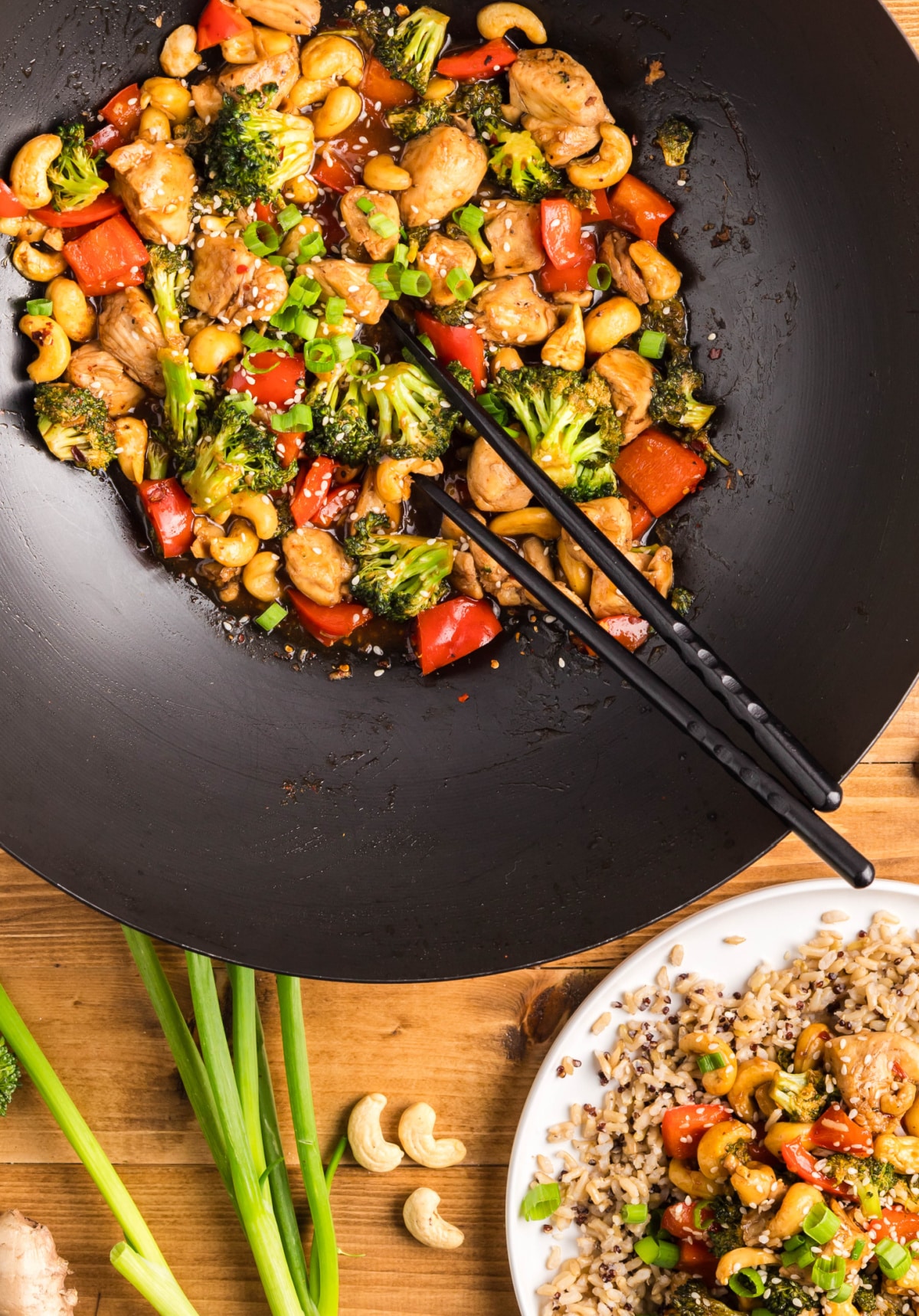 Wok with Cashew Chicken Stir-Fry and Finished Plate Overhead shot of cashew chicken in a wok next to a plated serving