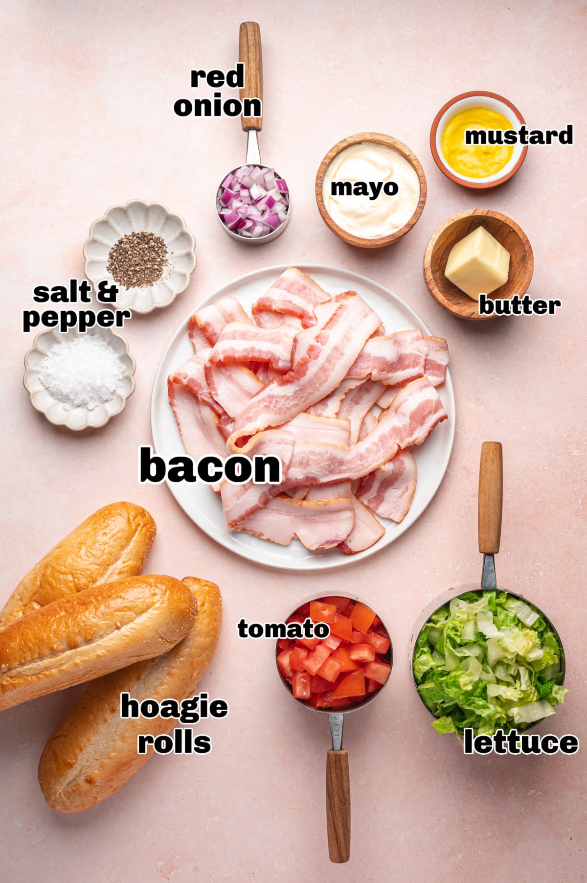 Chopped BLT hoagie ingredients laid out Ingredients for chopped BLT hoagie including bacon, lettuce, tomato, red onion, mayonnaise, mustard, and hoagie rolls