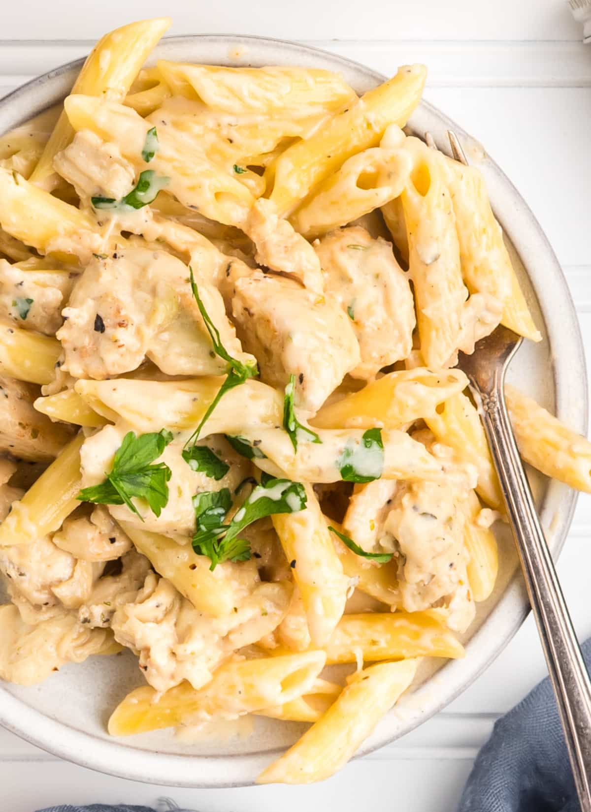 Creamy garlic chicken pasta on a plate with a fork