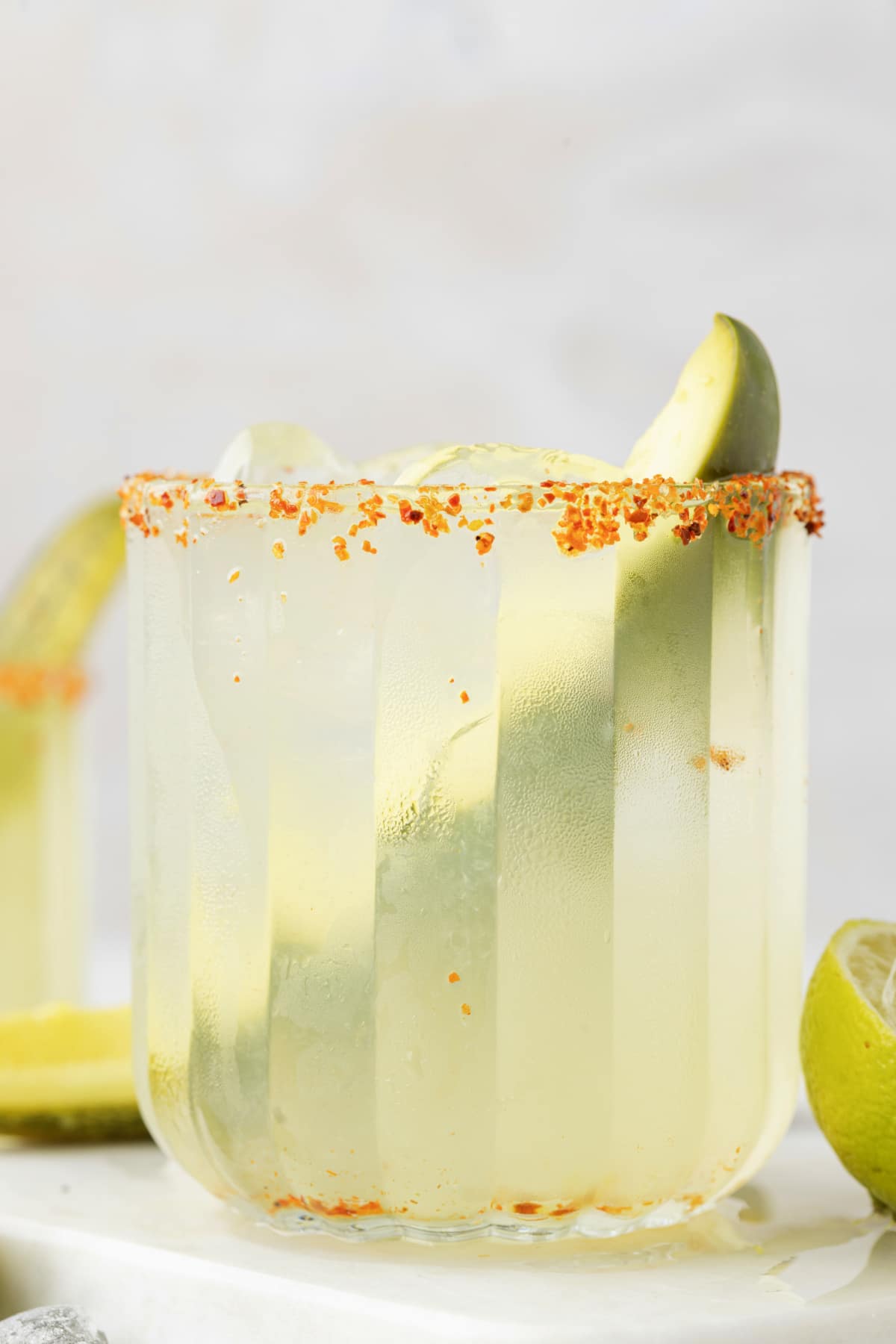 Side view of a dill pickle margarita on a marble surface