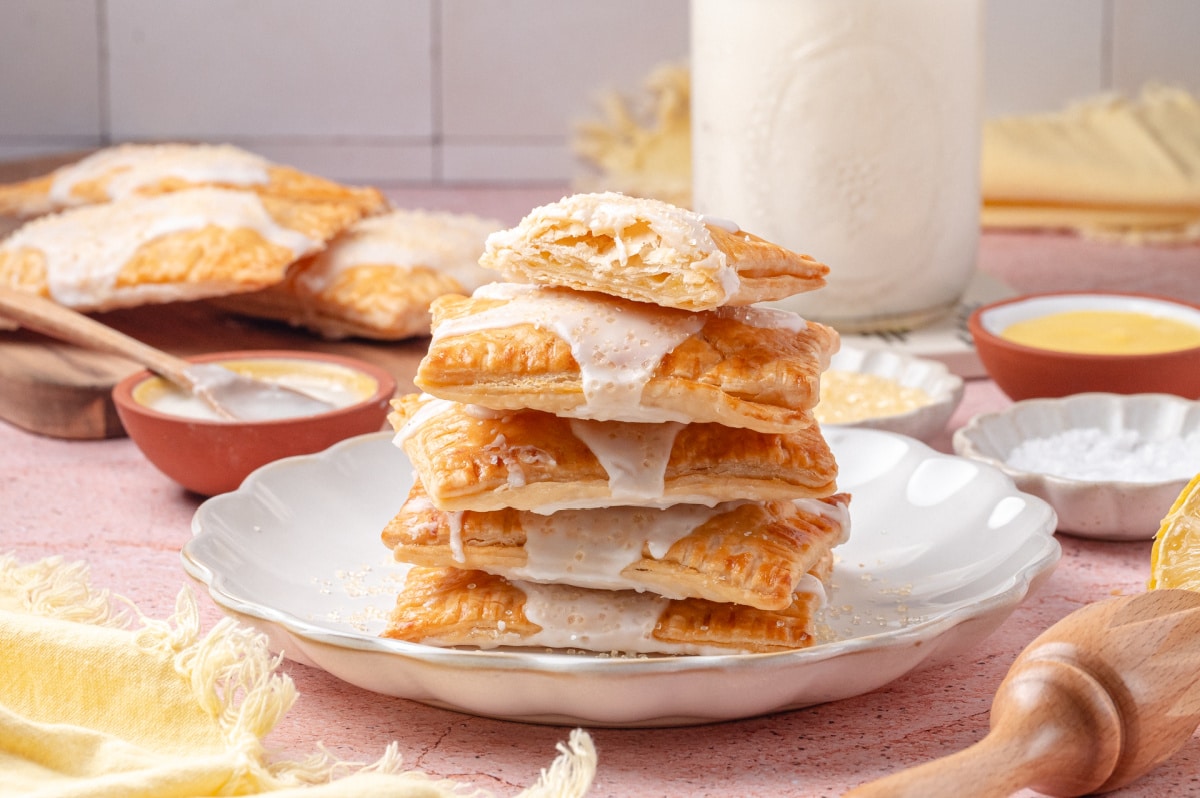 Flaky lemon toaster pastries stacked and ready to eat Stack of flaky lemon toaster pastries with a bite showing the lemon curd filling