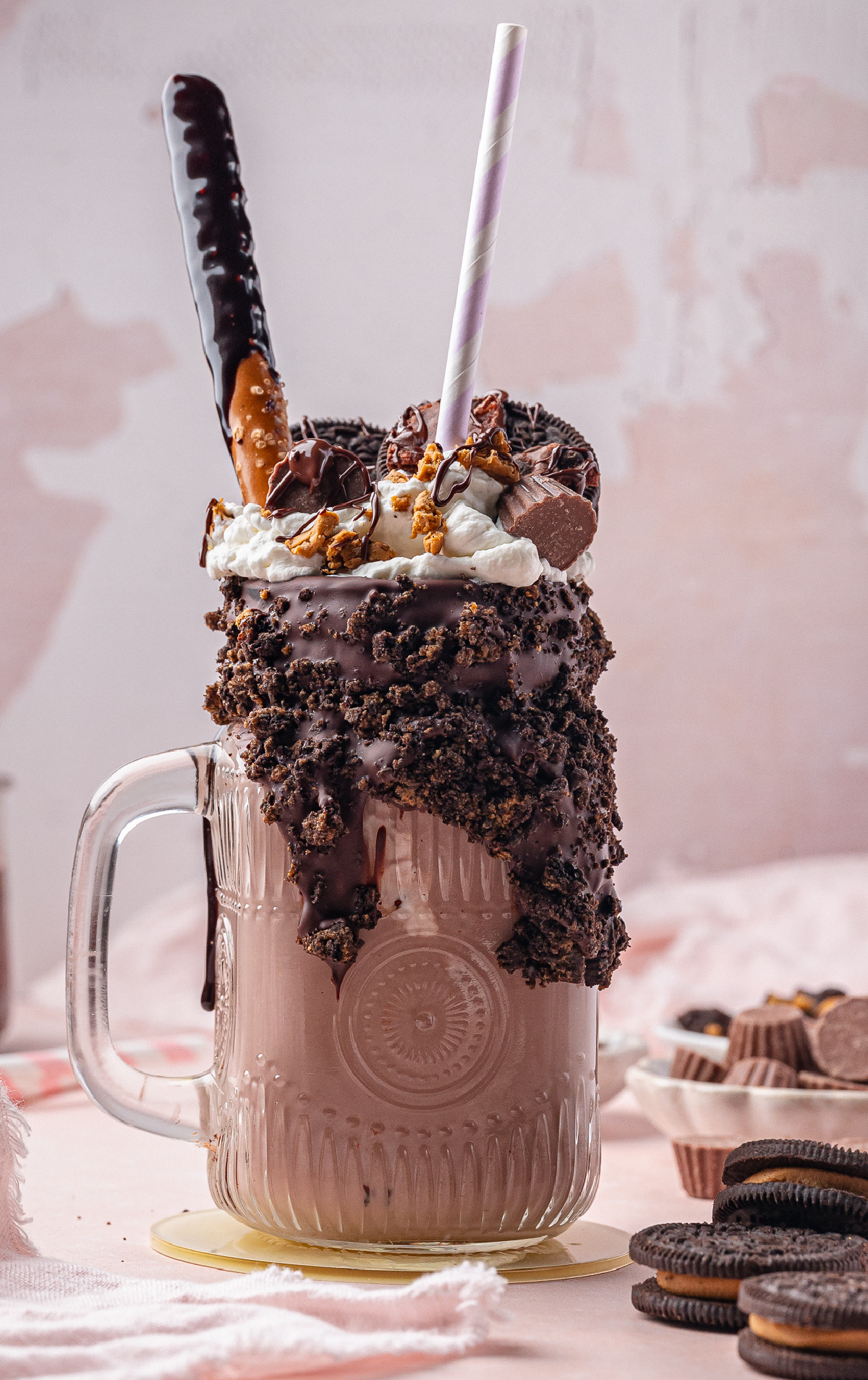 Ultimate chocolate freakshake with crunchy toppings and pink straw Freakshake with chocolate waffle, whipped cream, chocolate chips, and toffee rim