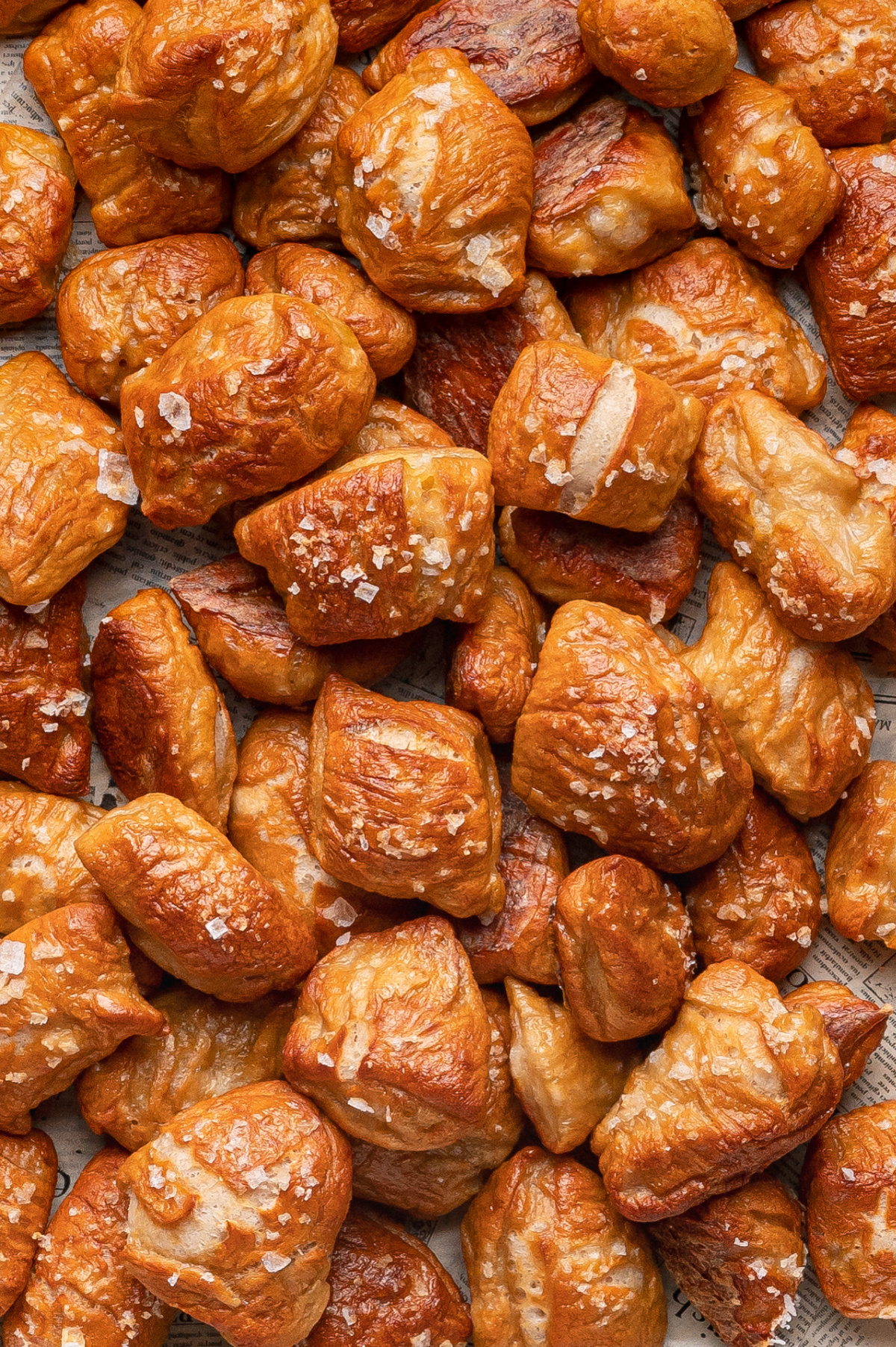 Homemade Soft Pretzel Bites on parchment, salty and golden brown golden homemade soft pretzel bites piled on parchment paper with coarse salt