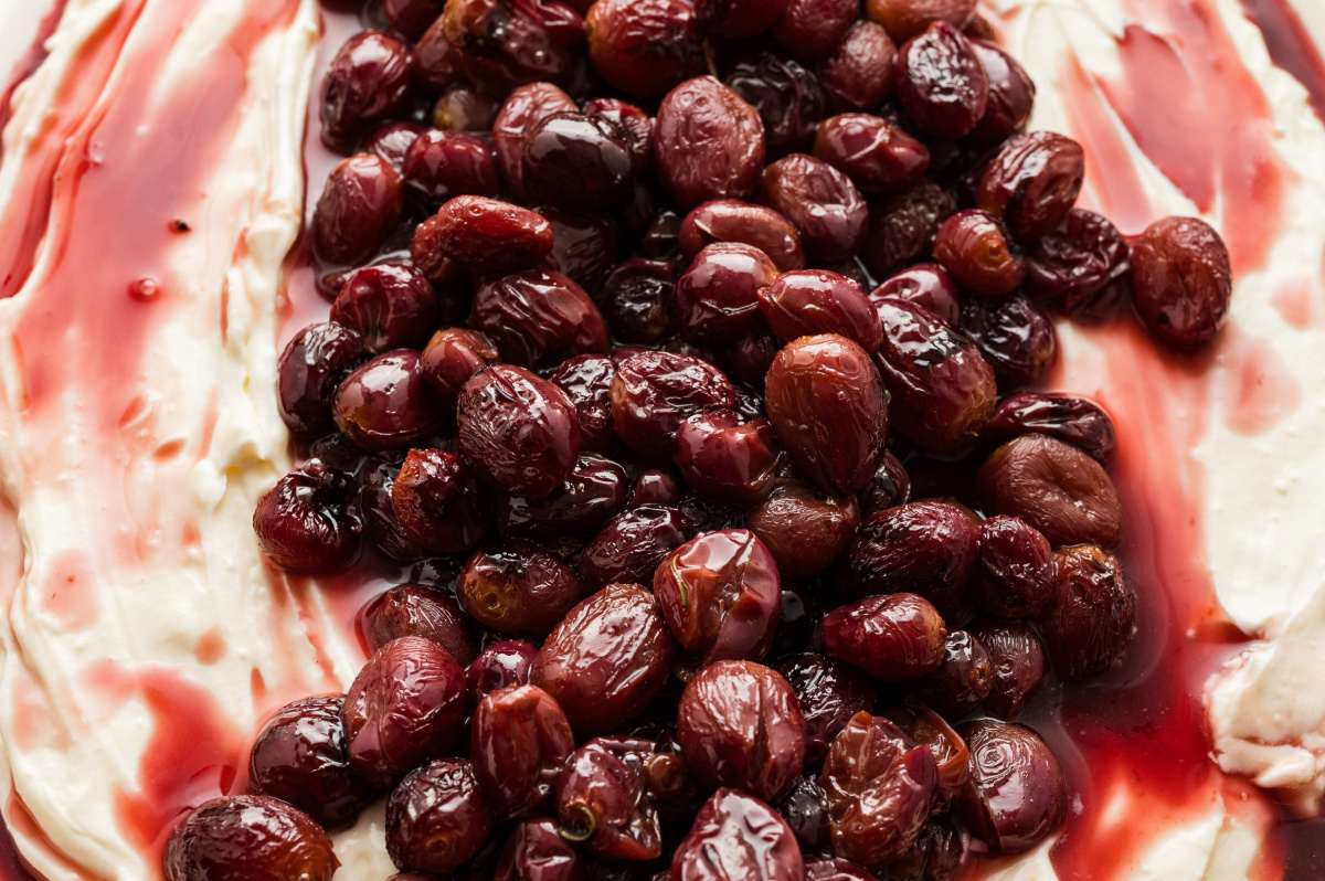 whipped ricotta appetizer topped with roasted grapes and syrupy balsamic close-up of roasted grapes layered over whipped ricotta and balsamic glaze