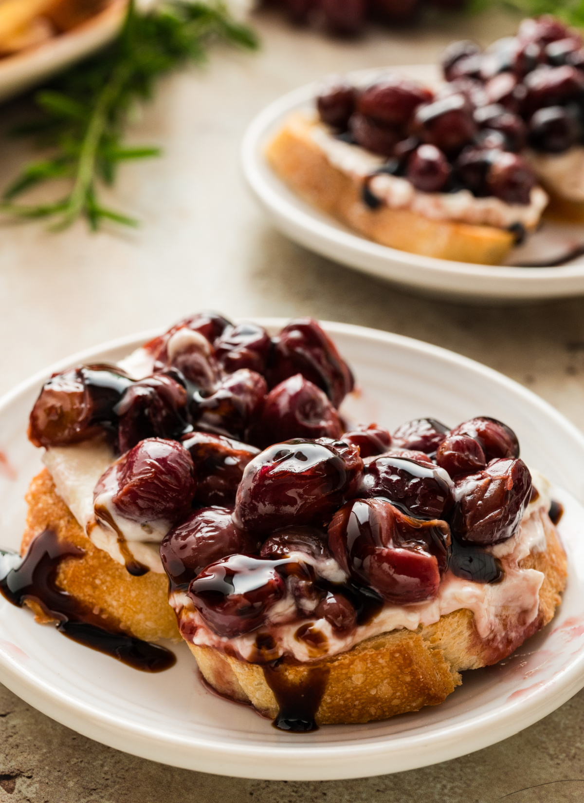 roasted grape and whipped ricotta crostini appetizer with balsamic glaze close-up of honey crostini with whipped ricotta and roasted grape topping drizzled with balsamic