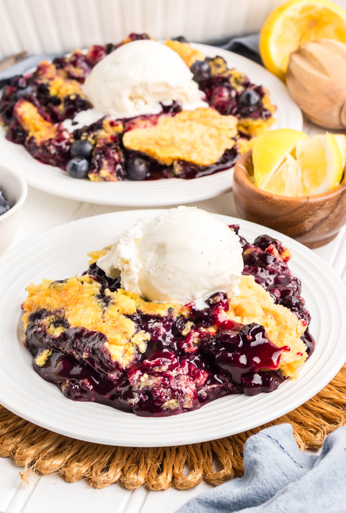 Buttery cake topping over juicy berry filling. Close-up of golden buttery crust with blueberry filling peeking through.