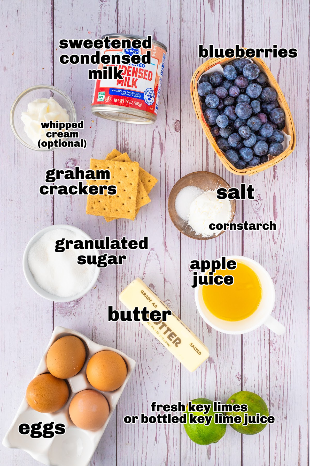 Ingredients for citrus and blueberry tart including graham crackers, blueberries, limes, and condensed milk.