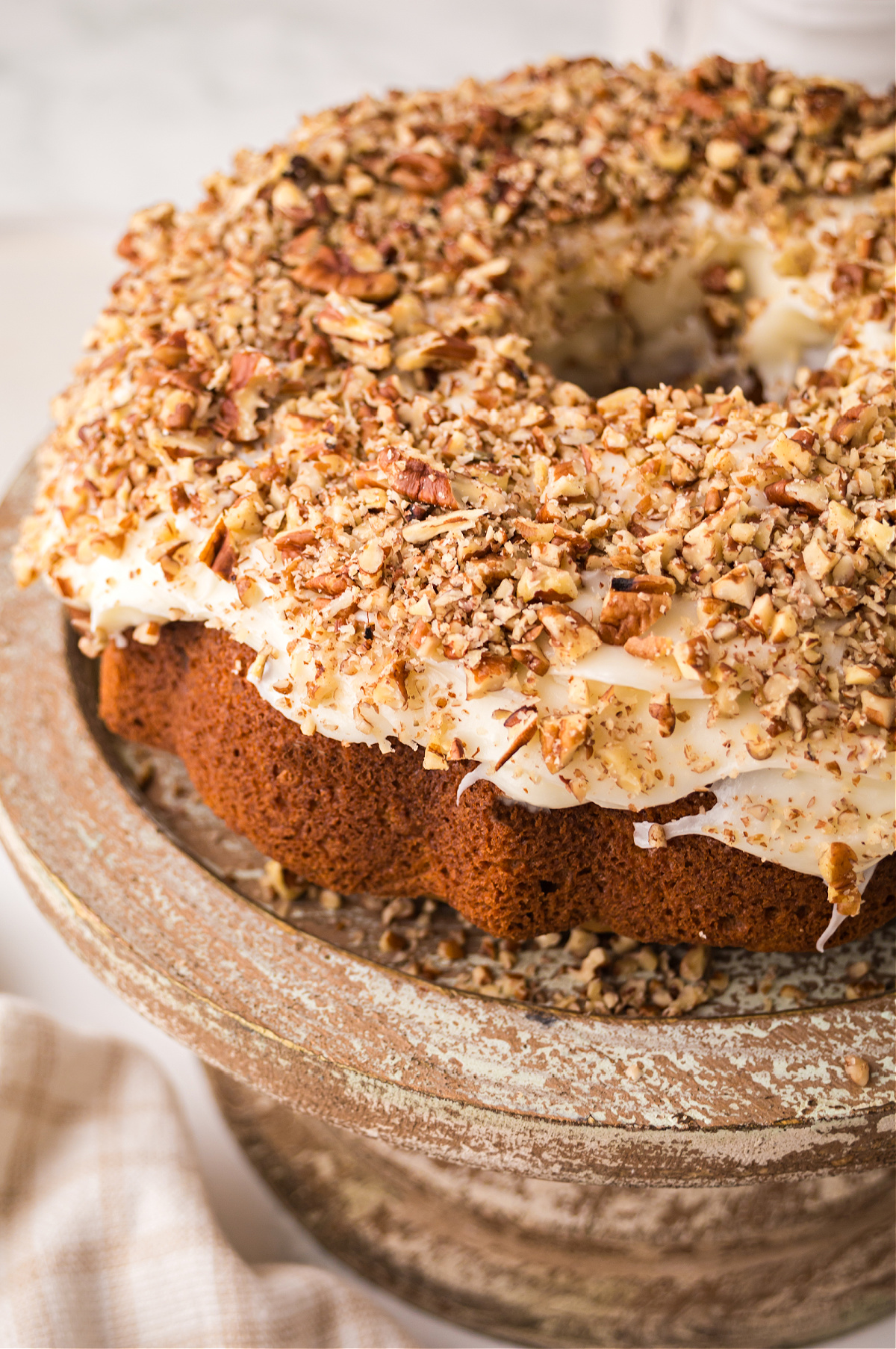 carrot bundt cake with cream cheese frosting Carrot bundt cake with cream cheese frosting and chopped walnuts on top.