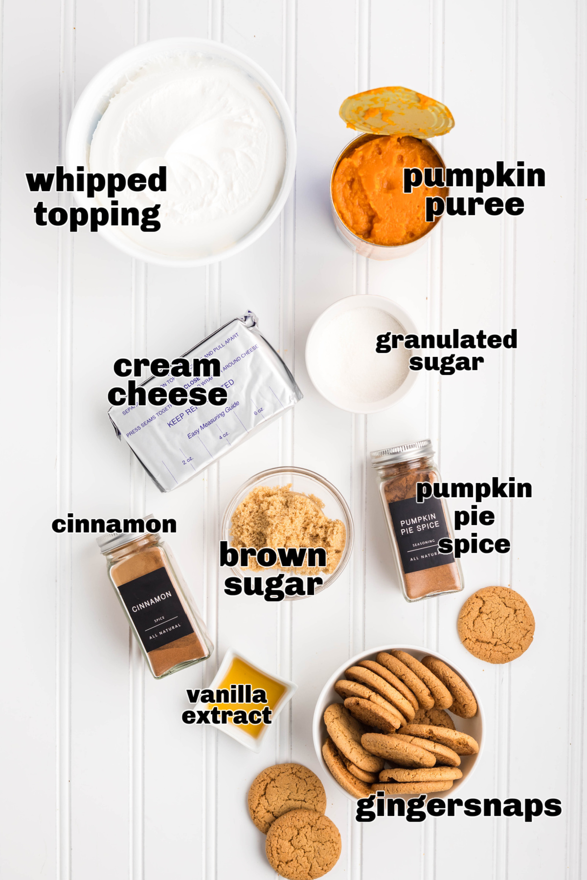 Ingredients for pumpkin refrigerator cake including pumpkin puree, cream cheese, spices, and gingersnaps