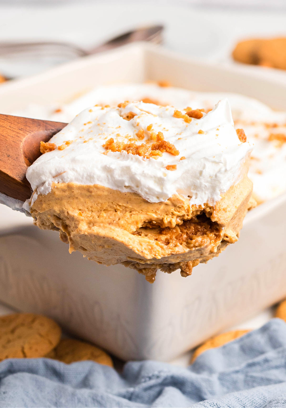 Pumpkin cream dessert lifted from pan showing soft cookie layers