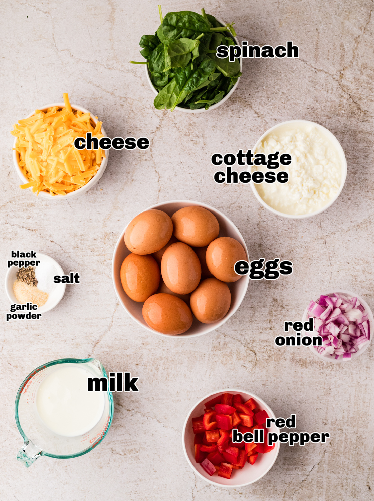 Ingredients for cottage cheese breakfast casserole including eggs, spinach, peppers, onion, and cheese