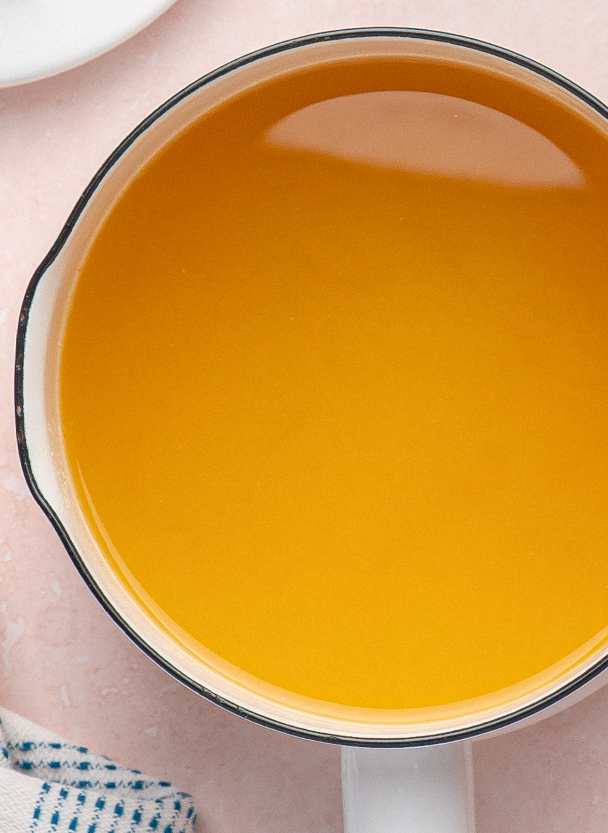 Warm pineapple hot sauce mixture simmering in a white saucepan before blending.