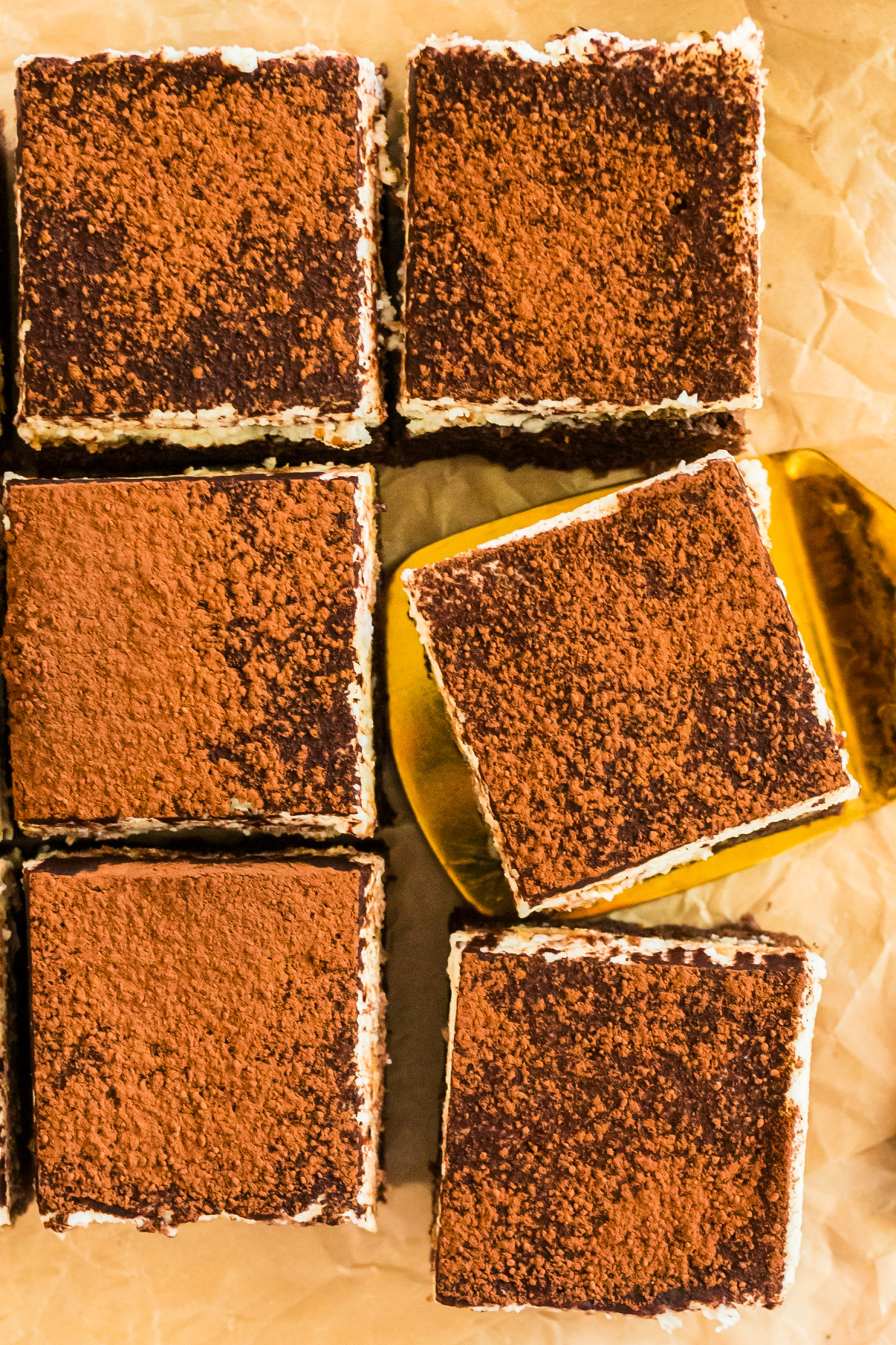 easy tiramisu dessert sliced into rich brownie-style portions. easy tiramisu dessert squares with cocoa powder topping and mascarpone filling.