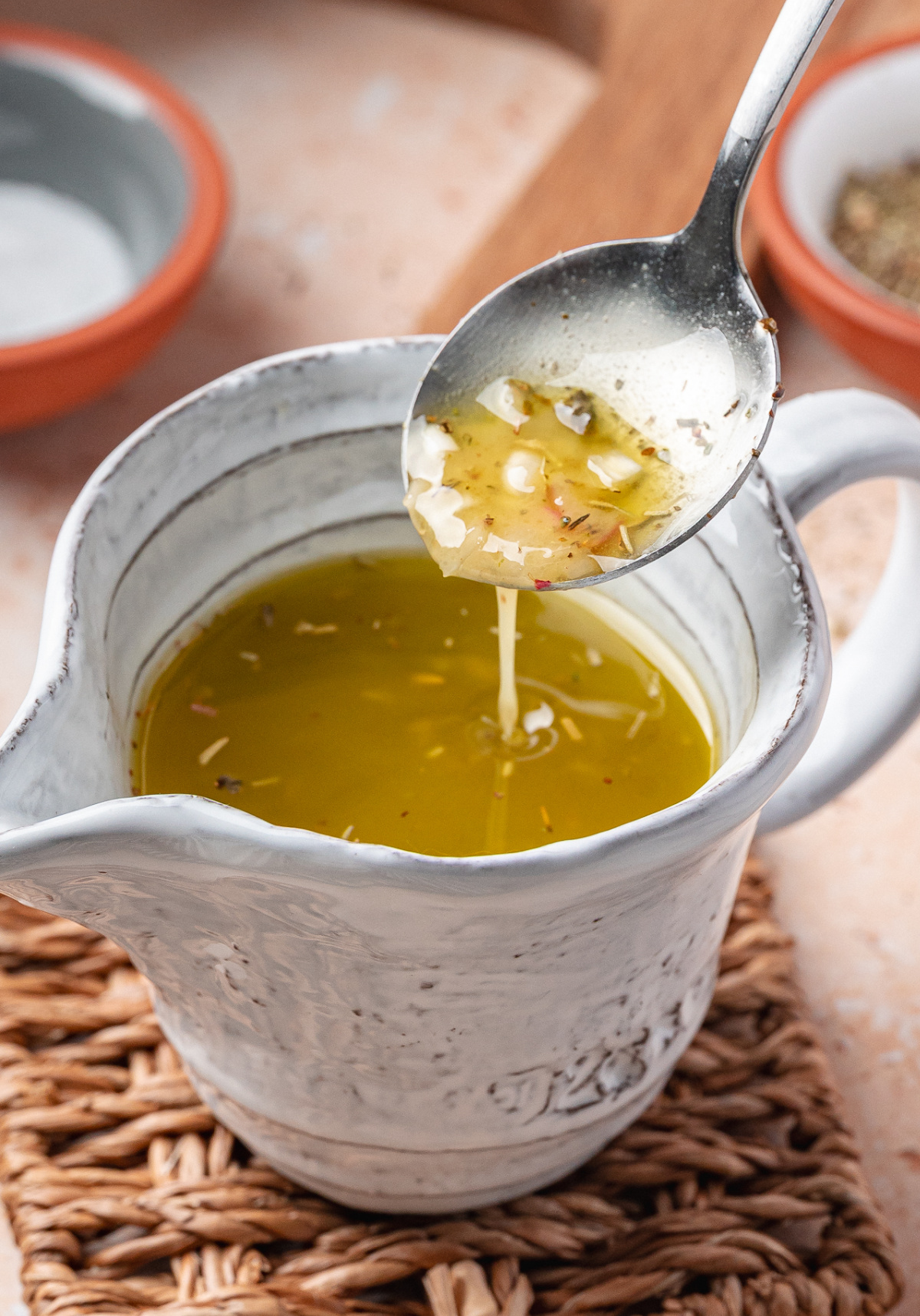 Tangy Homemade Vinaigrette Spoon lifting tangy vinaigrette to show its smooth texture