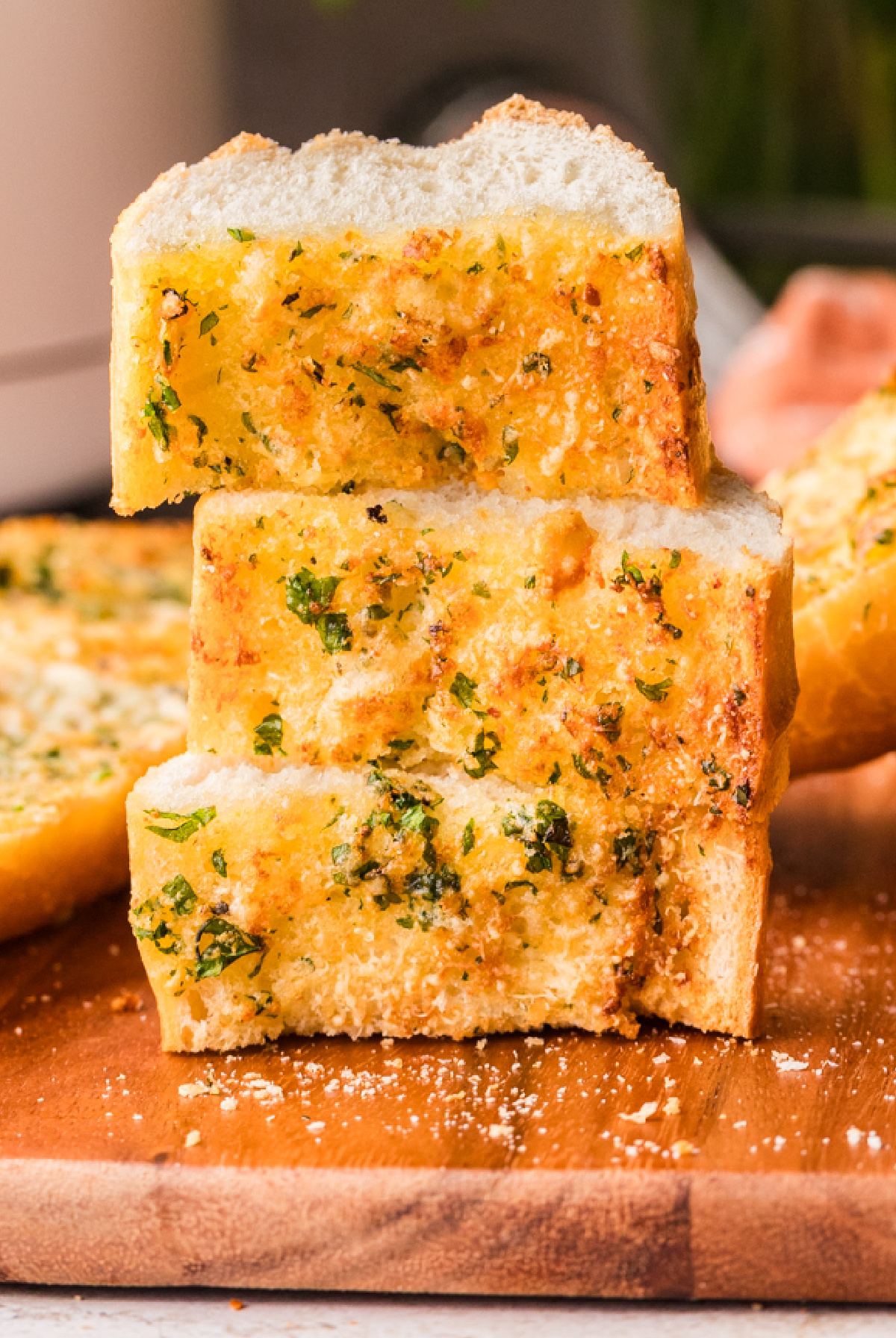 Thick slices of garlic confit bread stacked to show crisp edges and a tender crumb Stacked slices of crispy garlic bread made with garlic confit, showing a soft interior and golden crust
