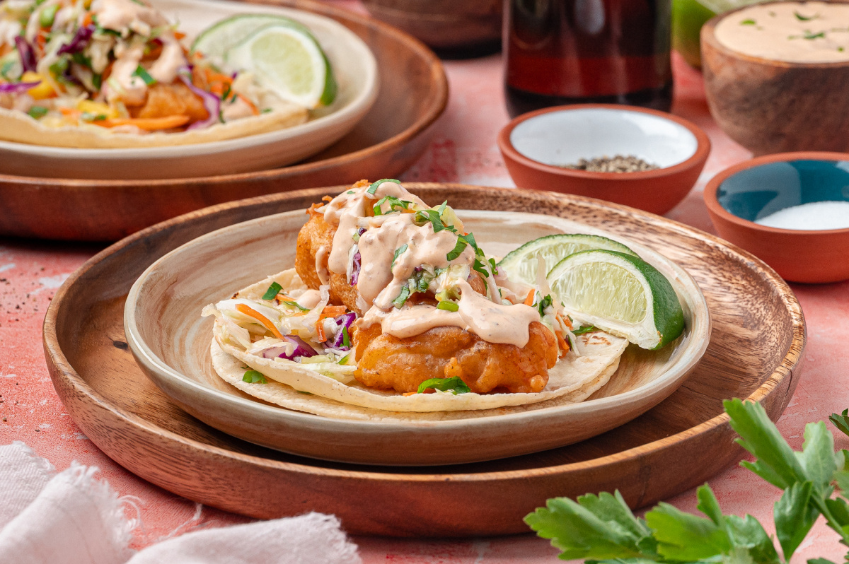 Crispy Fried Cod Tacos with Mango Slaw Crispy fried cod tacos topped with mango slaw and chipotle lime sauce on corn tortillas.
