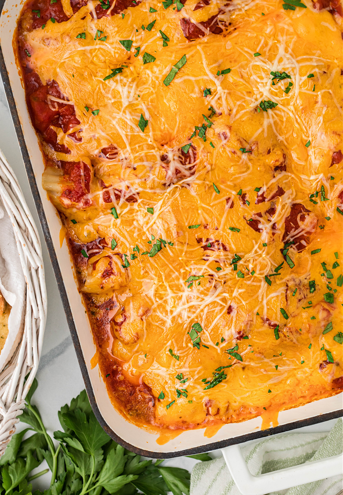 Baked manicotti in a 9×13 pan with marinara, ricotta filling, and melted sharp cheddar cheese
