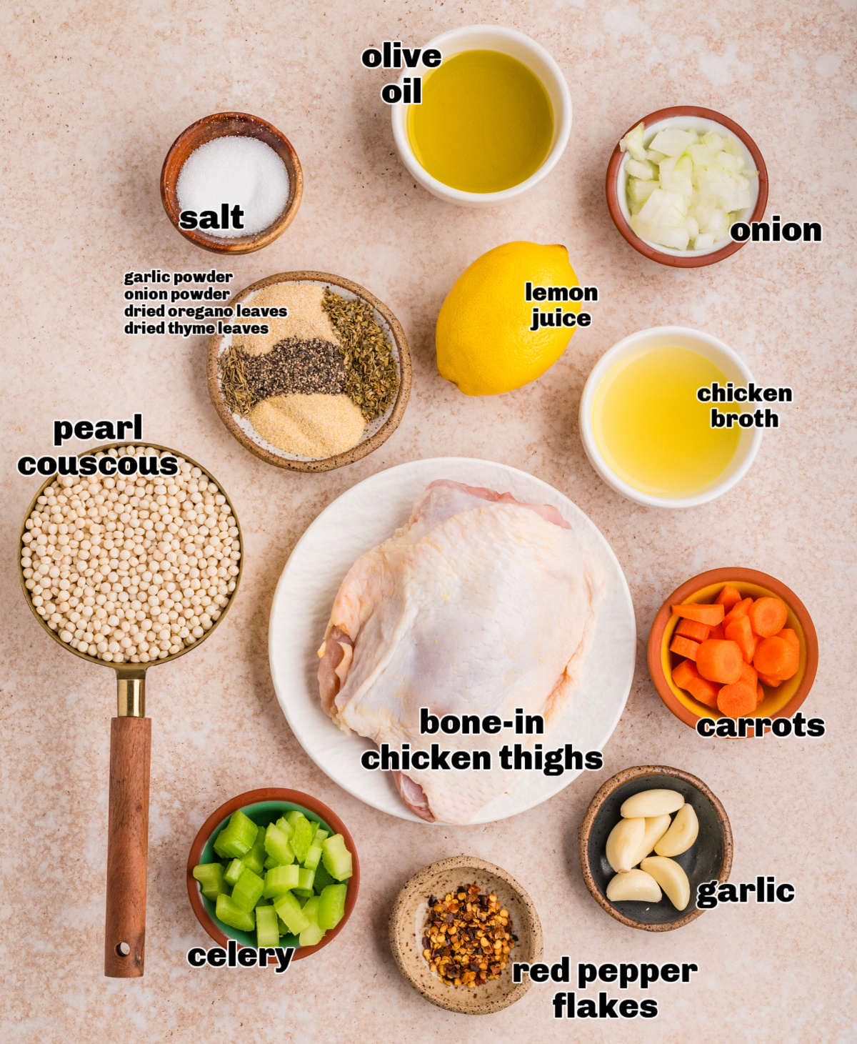 Measured ingredients for making chicken thighs with pearl couscous, shown raw and ready to cook on a neutral surface. Ingredients for chicken thighs and pearl couscous, including olive oil, lemon juice, broth, vegetables, herbs, and spices arranged on a countertop.