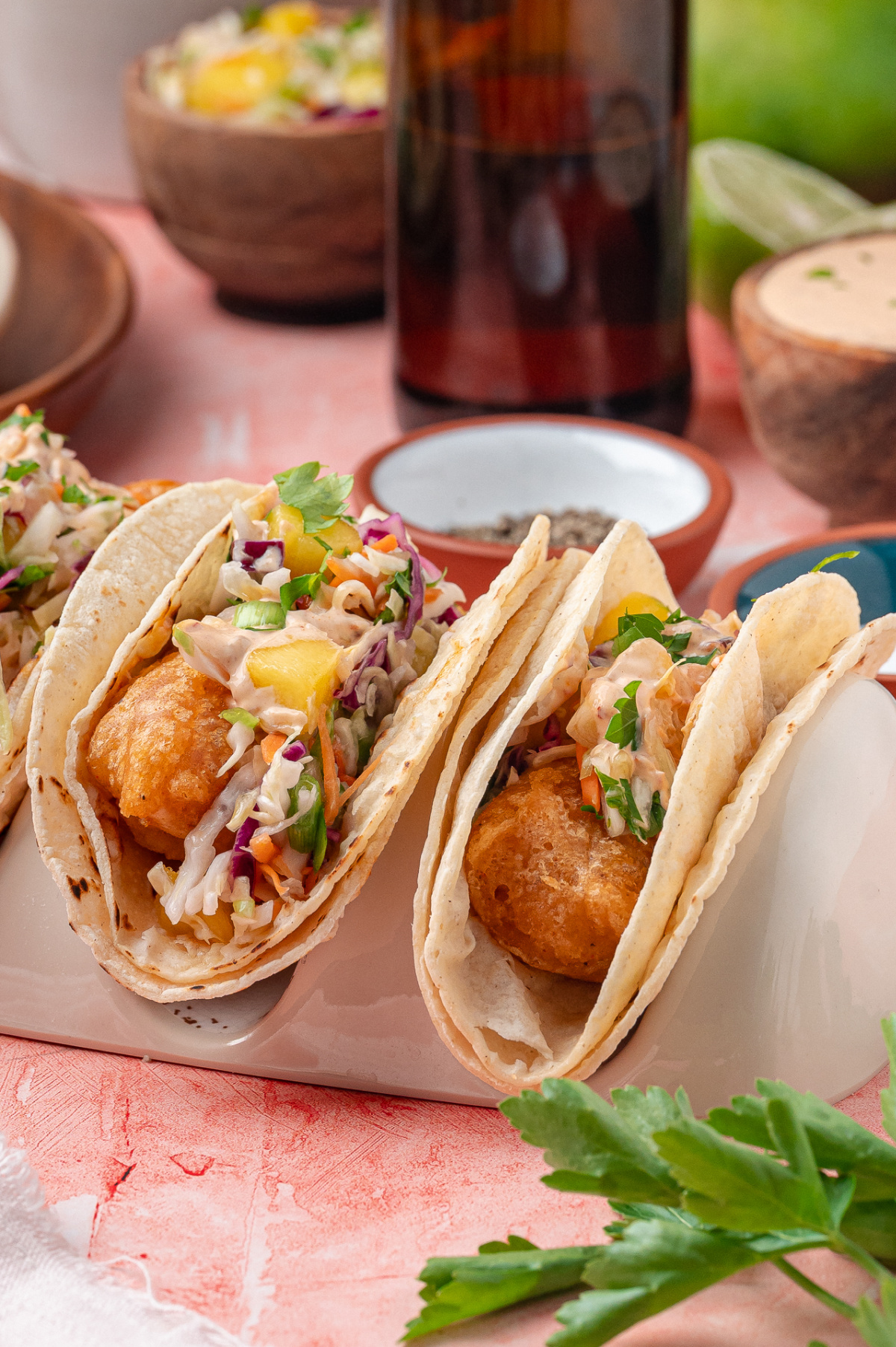 Crispy Fried Cod Tacos with Mango Slaw Crispy fried cod in warm corn tortillas with mango slaw and chipotle lime sauce.