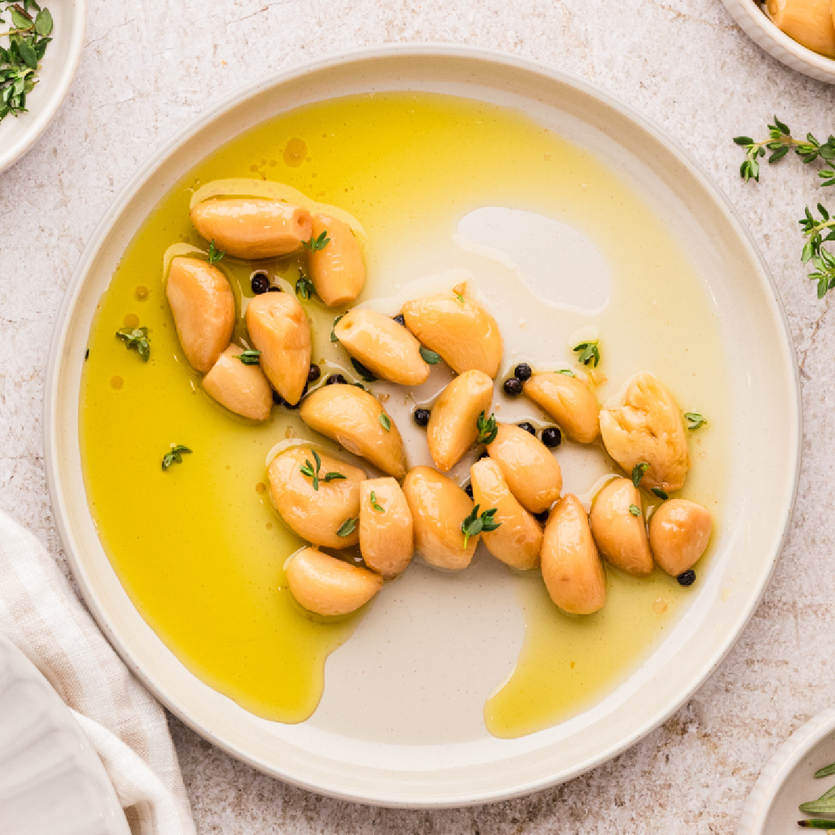 Garlic confit made in the oven, showing soft garlic cloves in olive oil and spread on toasted bread.