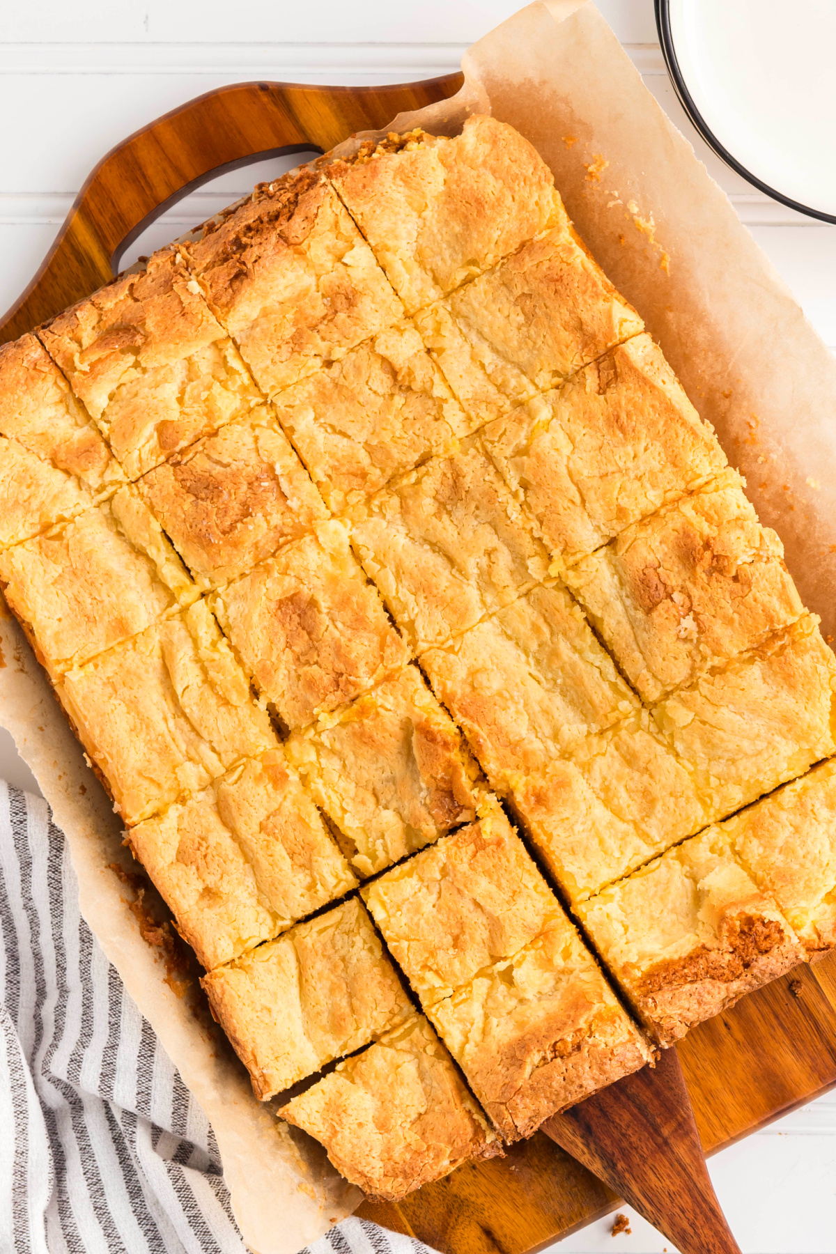 Gooey butter cake with a crackled top and soft, buttery interior. Freshly baked gooey butter cake viewed at an angle, highlighting the crackled surface and tender texture.
