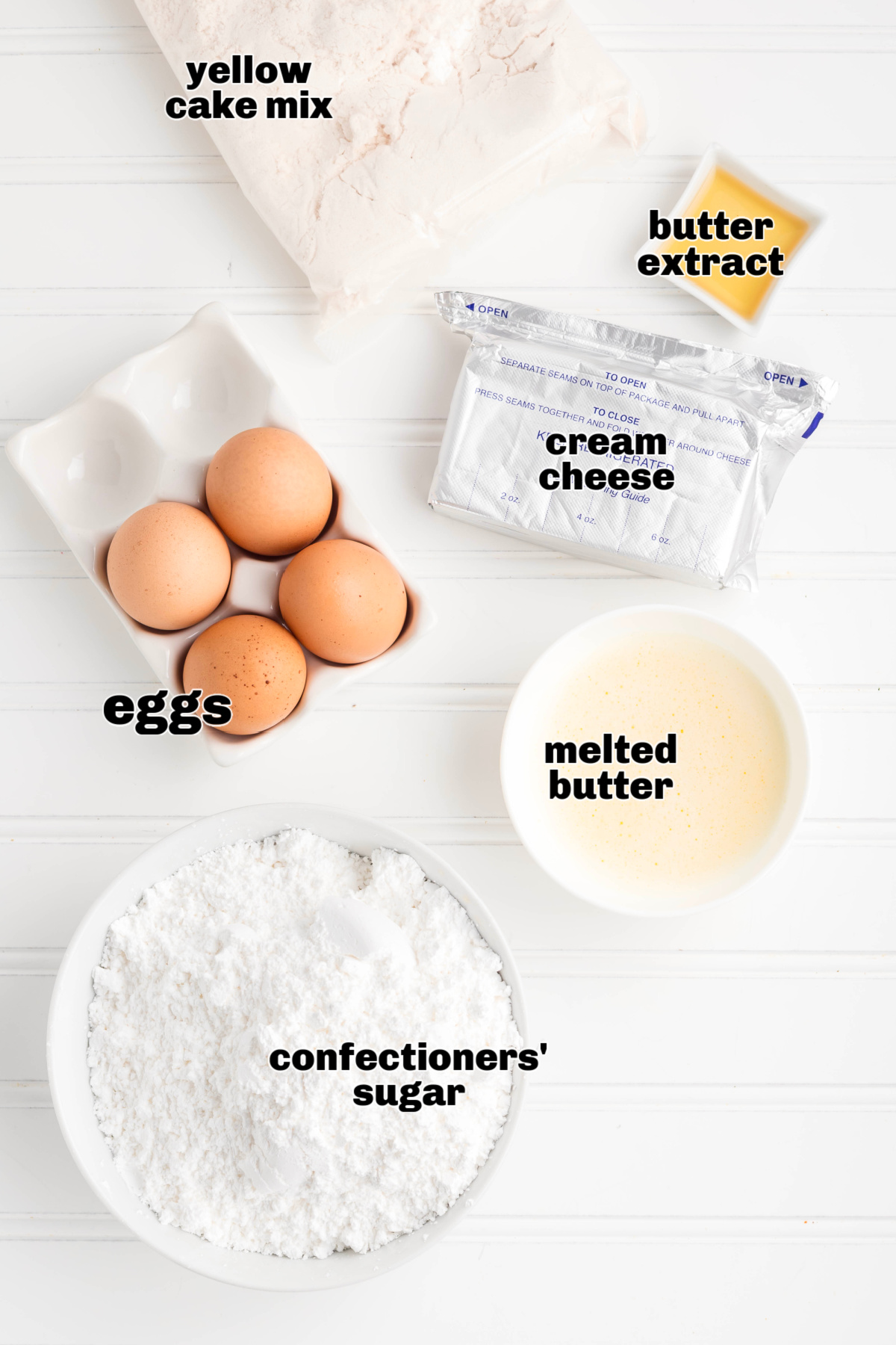 Ingredients for cream cheese butter cake including cake mix, cream cheese, eggs, and butter. Ingredients for a classic cream cheese butter cake including yellow cake mix, cream cheese, eggs, melted butter, butter extract, and confectioners’ sugar.