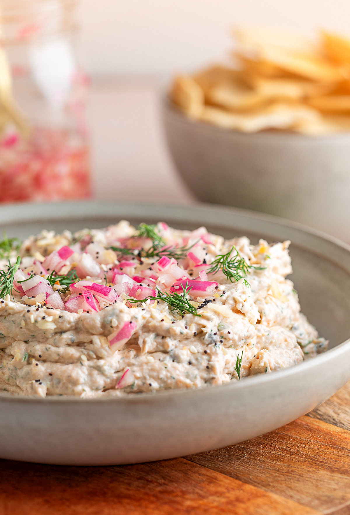 Smoked salmon dip finished with pickled red onions and dill, ready to serve as a dip or bagel spread. Smoked salmon dip topped with quick-pickled red onions, fresh dill, and everything bagel seasoning in a shallow serving bowl.