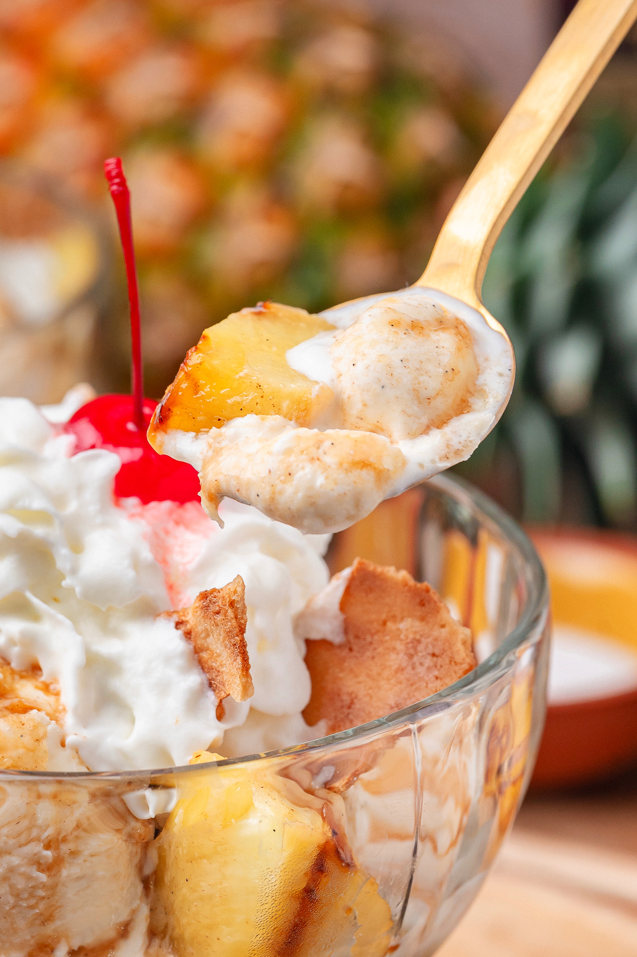 Caramelized Pineapple with Rum Sauce Spoonful of grilled pineapple sundae with hot buttered rum sauce and melting vanilla ice cream