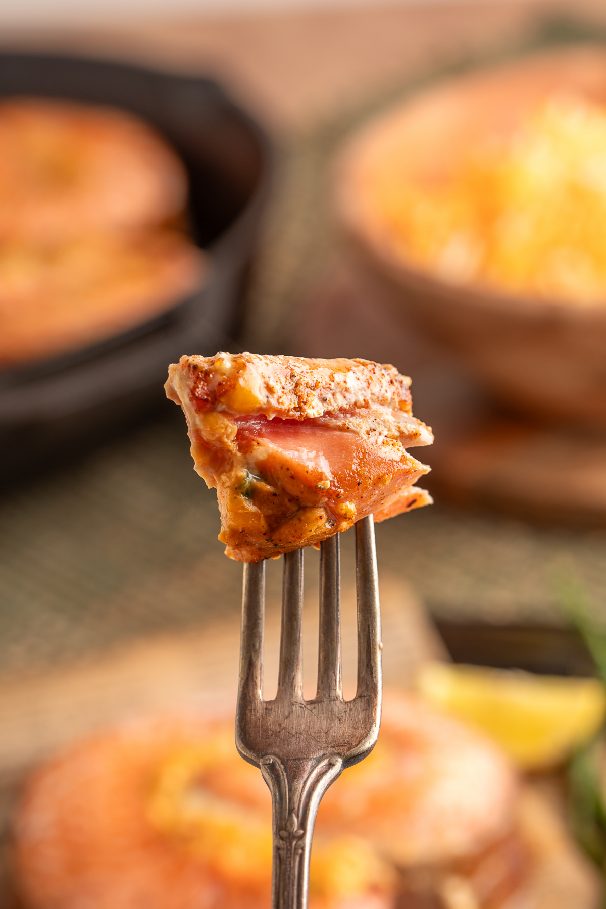 Close-up of a fork lifting a bite of baked stuffed salmon, showing tender layers of salmon and creamy jalapeño popper-style filling. Close-up of a fork lifting a bite of baked stuffed salmon, showing tender layers of salmon and creamy jalapeño popper-style filling.