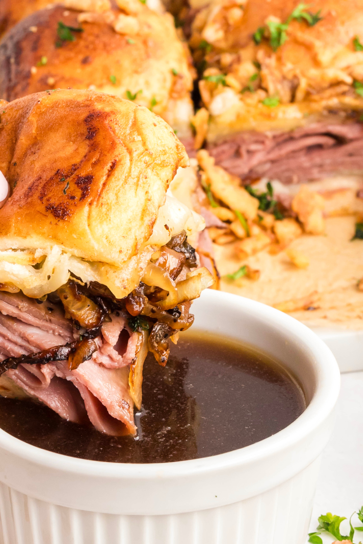 Roast beef slider dipped into au jus with caramelized onions and melted provolone