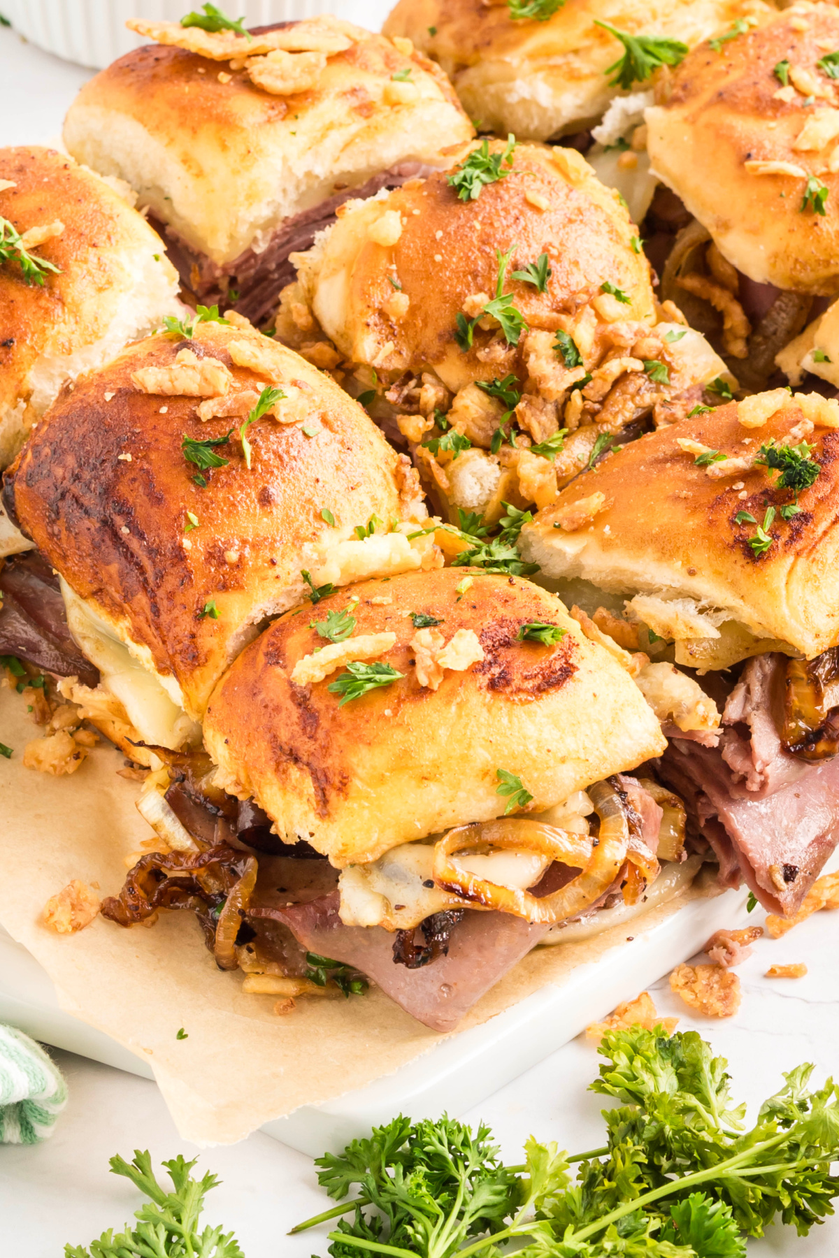 Roast beef sliders on Hawaiian rolls with melted provolone and caramelized onions