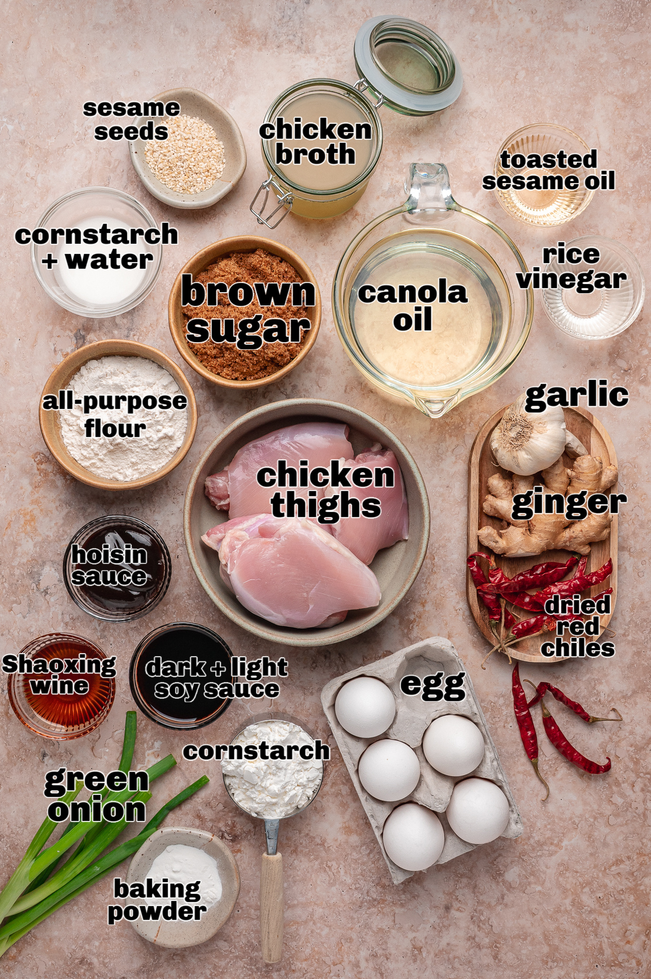 Overhead view of measured ingredients arranged for making sweet and savory fried chicken Ingredients for General Tso’s chicken including chicken thighs, soy sauce, brown sugar, garlic, ginger, and dried red chilies