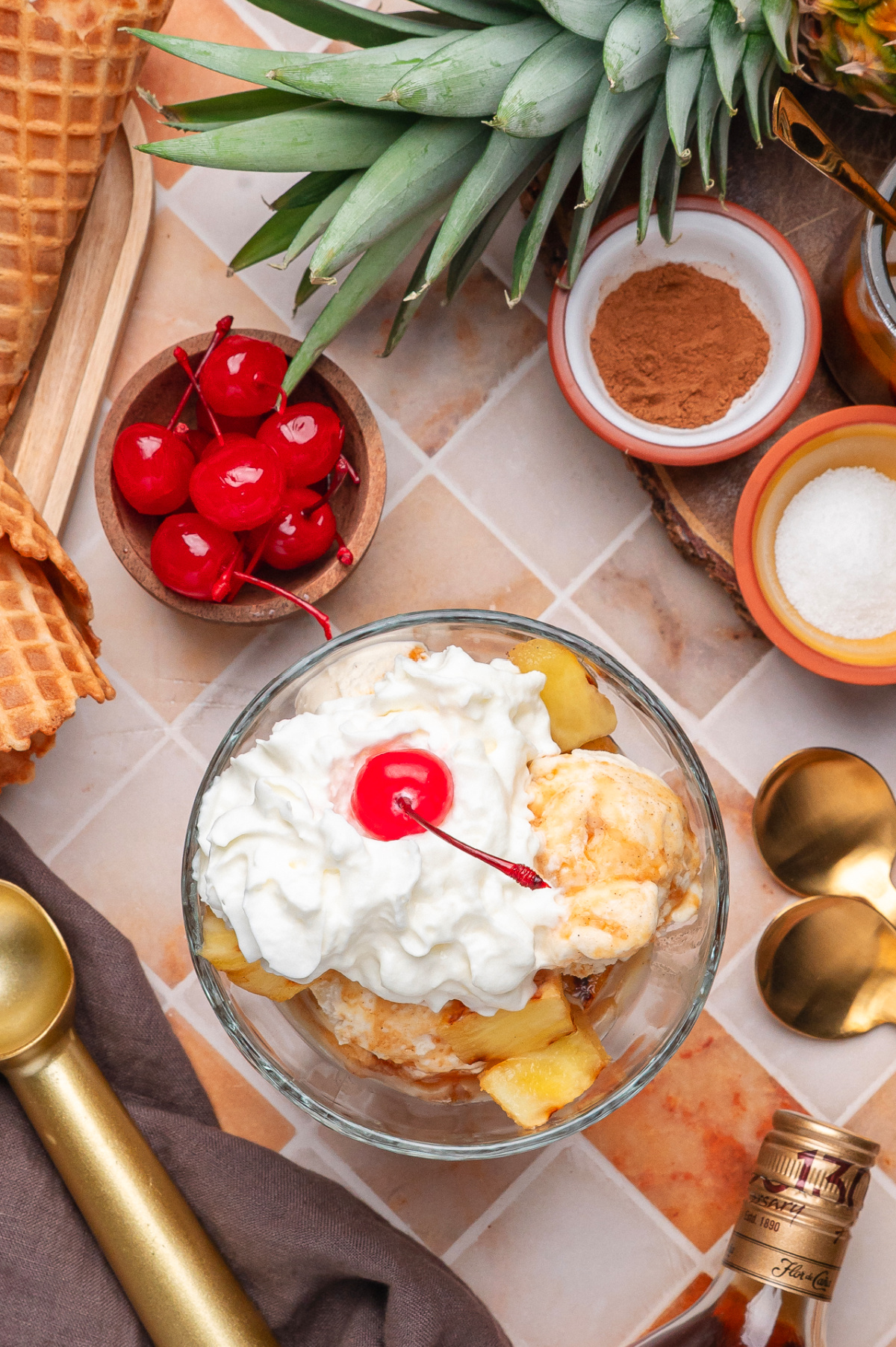 Grilled Pineapple with Rum Sauce Overhead View Overhead view of grilled pineapple with vanilla ice cream, whipped cream, cherries, cinnamon, and rum