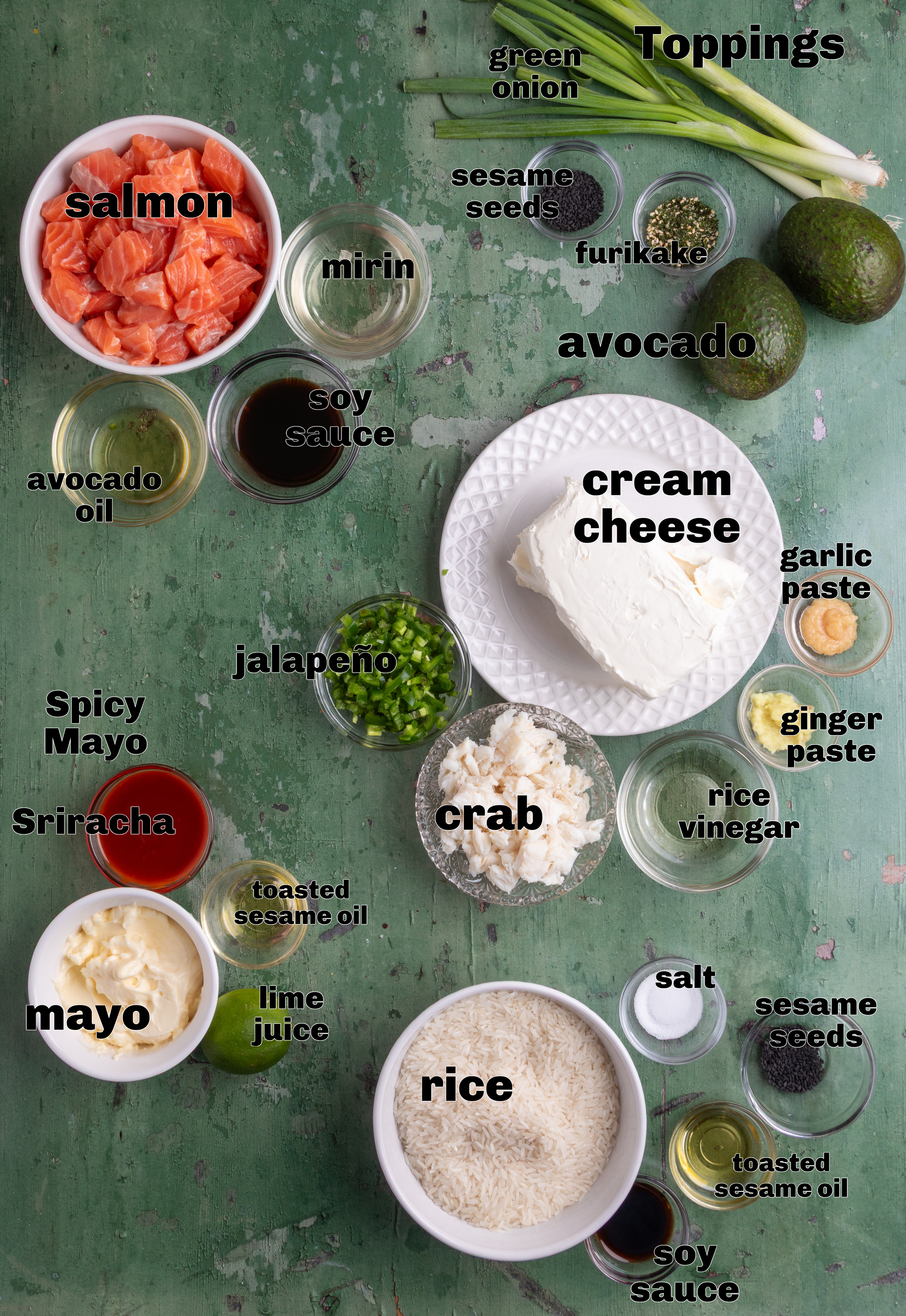 Ingredients for sushi bake including salmon, lump crab, jasmine rice, cream cheese, jalapeño, soy sauce, mirin, mayonnaise, Sriracha, avocado, sesame seeds, and green onions