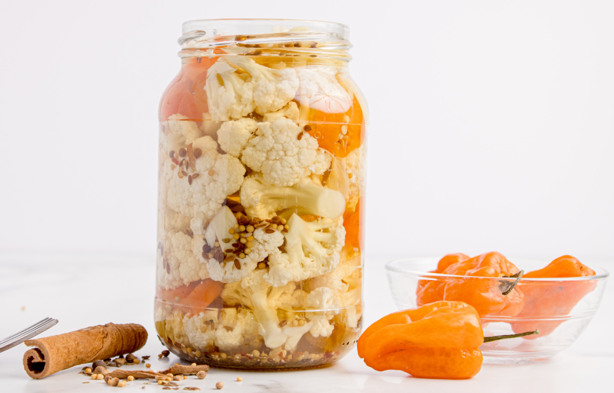 Spicy pickled cauliflower packed in a mason jar with habanero peppers and whole pickling spices