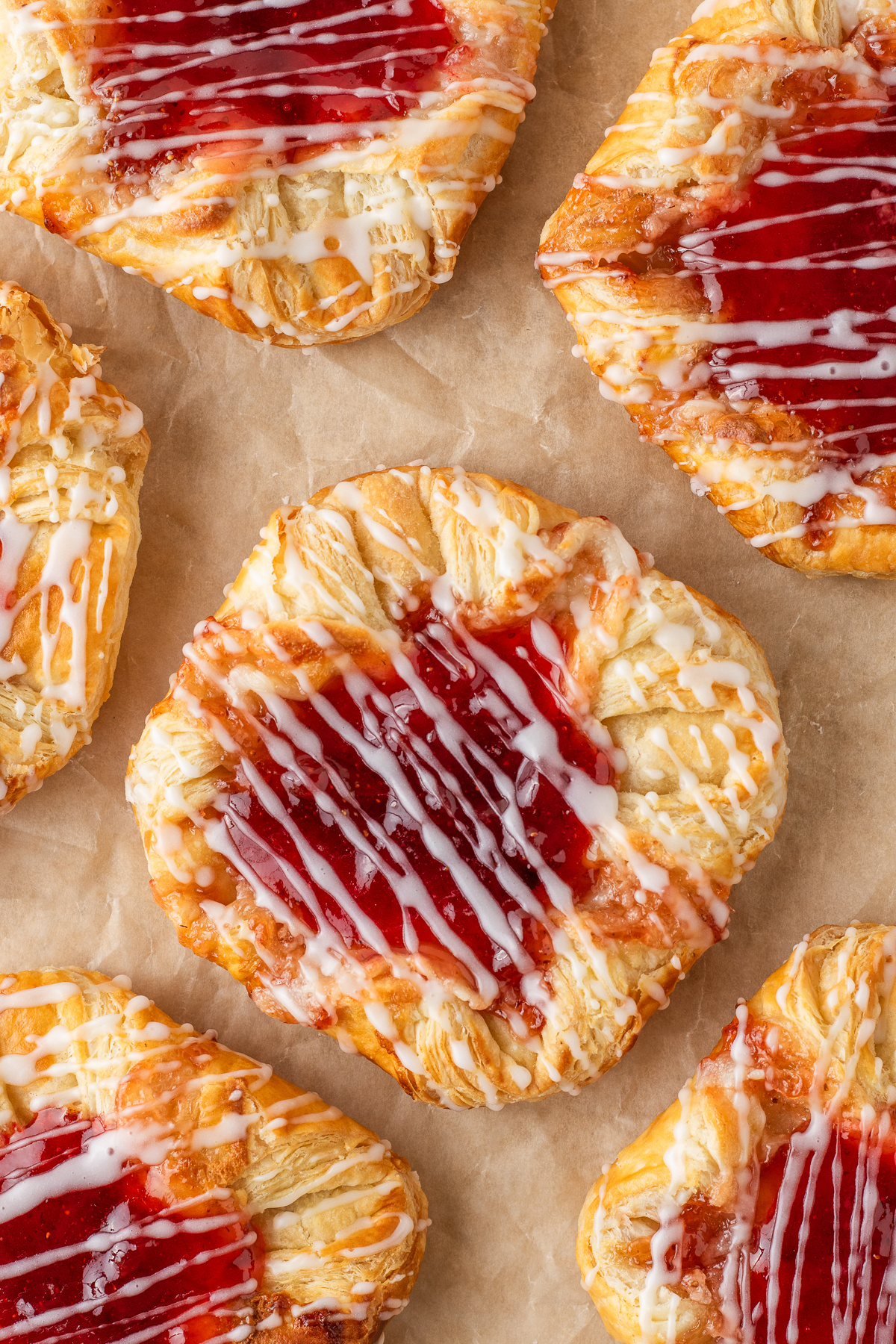 strawberry cream cheese danishes with flaky puff pastry, strawberry jam centers, and vanilla glaze drizzle