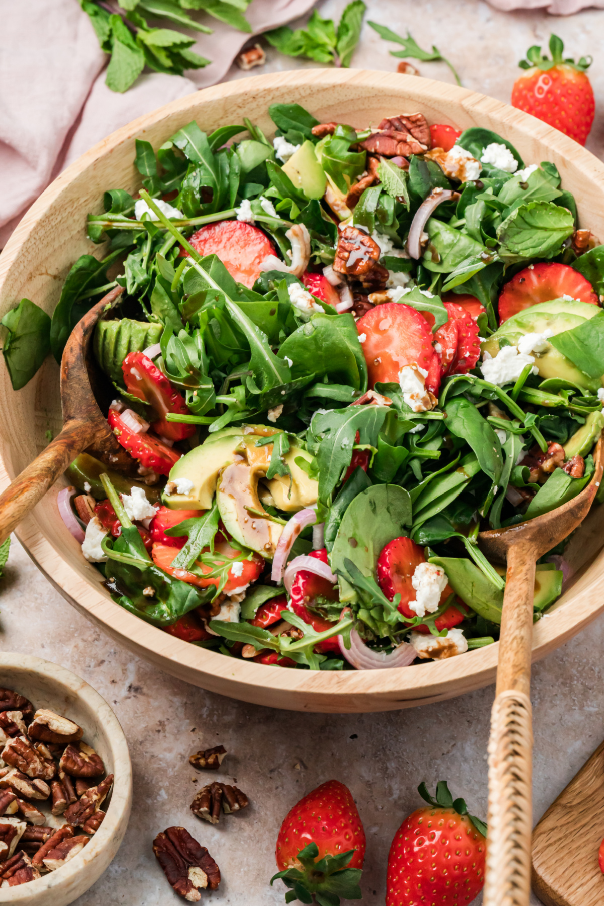 Strawberry Goat Cheese Salad with Avocado and Pecans Strawberry goat cheese salad with avocado, pecans, and greens as balsamic vinaigrette is poured over the top