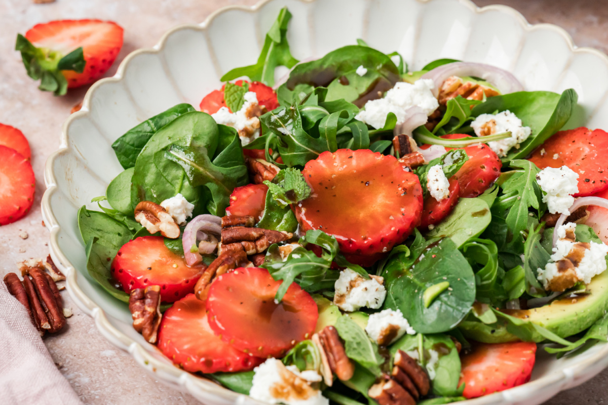 Strawberry Goat Cheese Salad Close-Up with Balsamic Dressing Strawberry goat cheese salad with spinach, arugula, avocado, pecans, and balsamic vinaigrette close-up