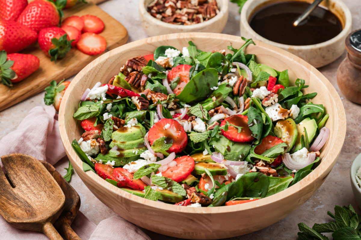 Strawberry Spinach Goat Cheese Salad with Balsamic Dressing Strawberry spinach goat cheese salad with avocado, toasted pecans, and balsamic vinaigrette in a wooden bowl