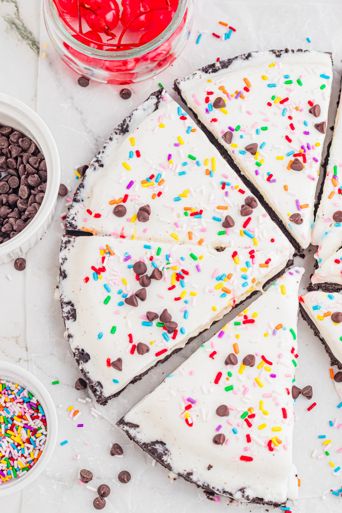 Close Up Ice Cream Pizza with Oreo Crust and Toppings close up of ice cream pizza slices with Oreo crust, sprinkles, and chocolate chips