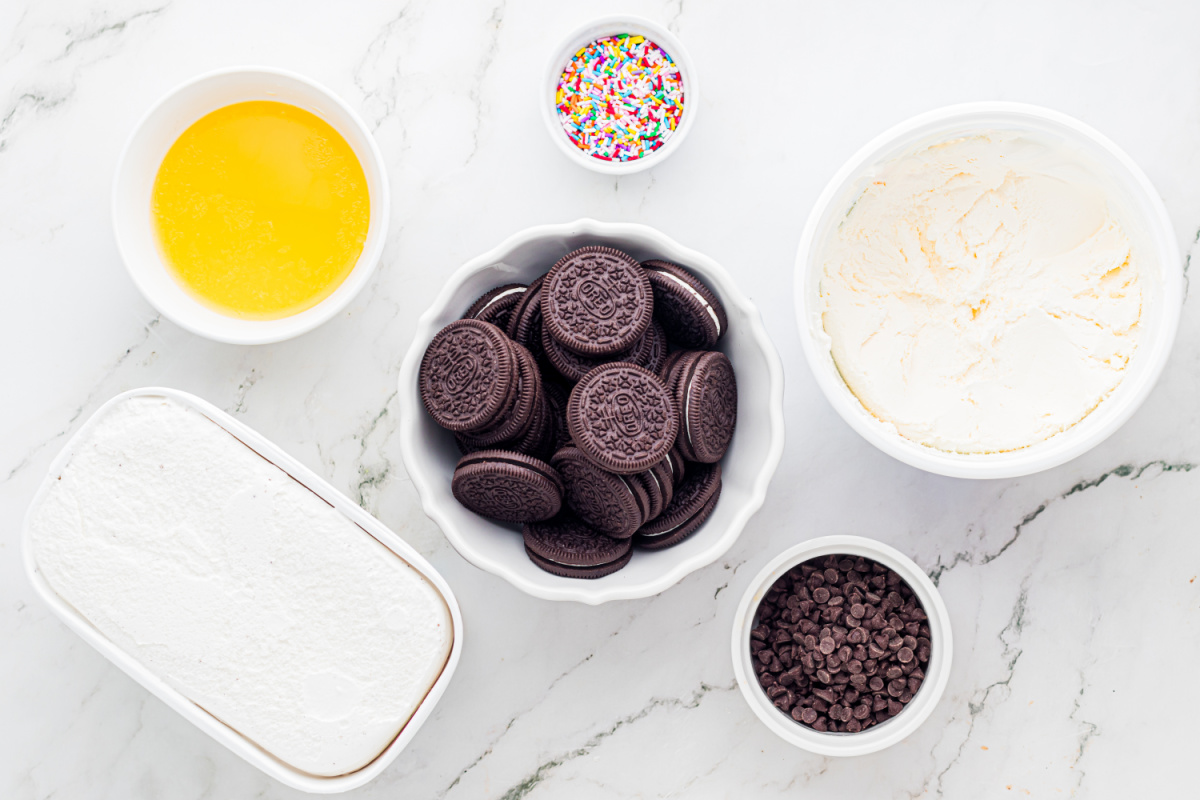 Ingredients for Oreo Crust Ice Cream Dessert ingredients for Oreo crust ice cream dessert including sandwich cookies, butter, ice cream, sprinkles, and chocolate chips
