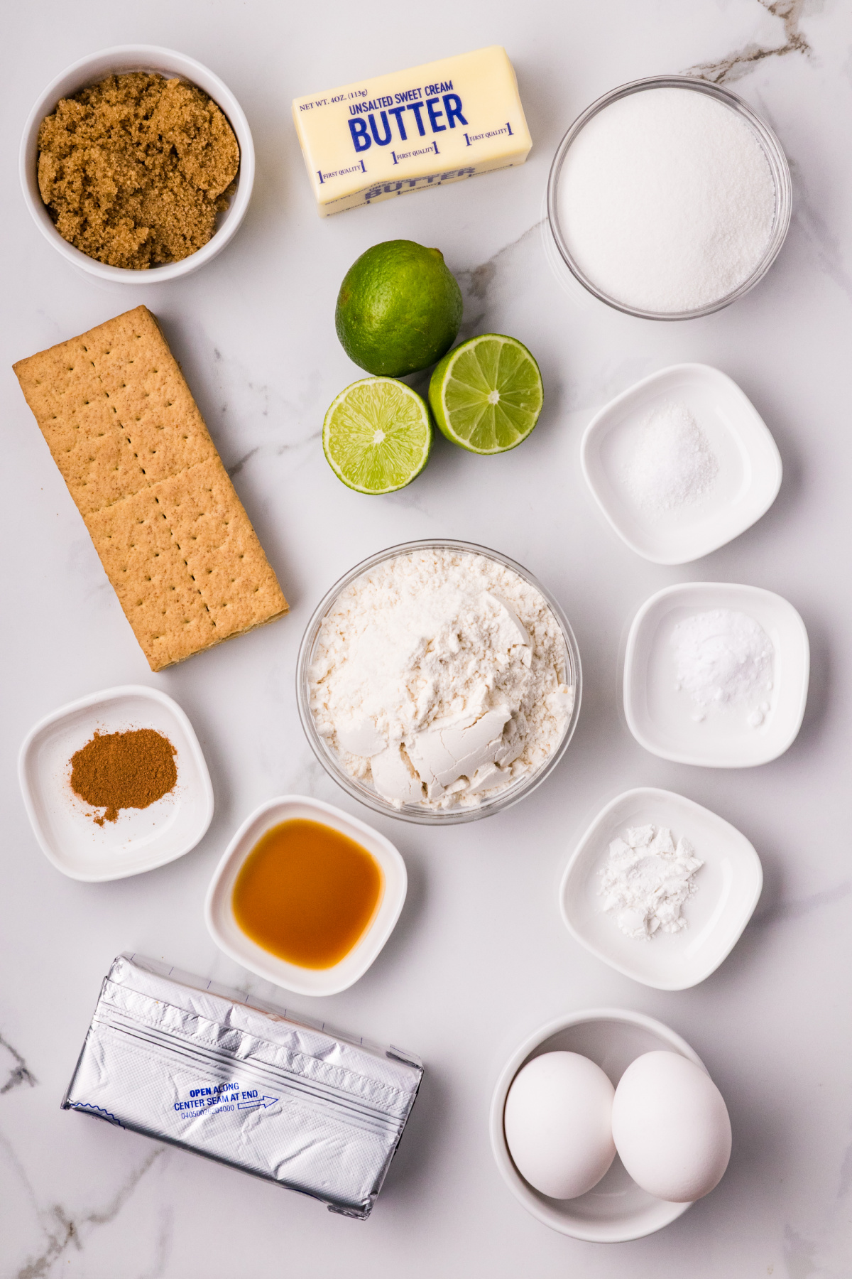 ingredients laid out for graham cracker lime cookies ingredients for lime cookies including graham crackers, fresh limes, butter, flour, sugar, and eggs