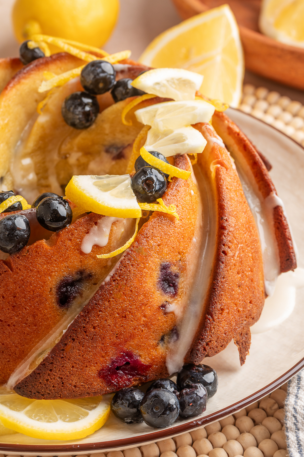 Lemon blueberry sour cream bundt cake with glaze and fresh lemon Lemon blueberry sour cream bundt cake with lemon glaze, fresh blueberries, and lemon slices on top