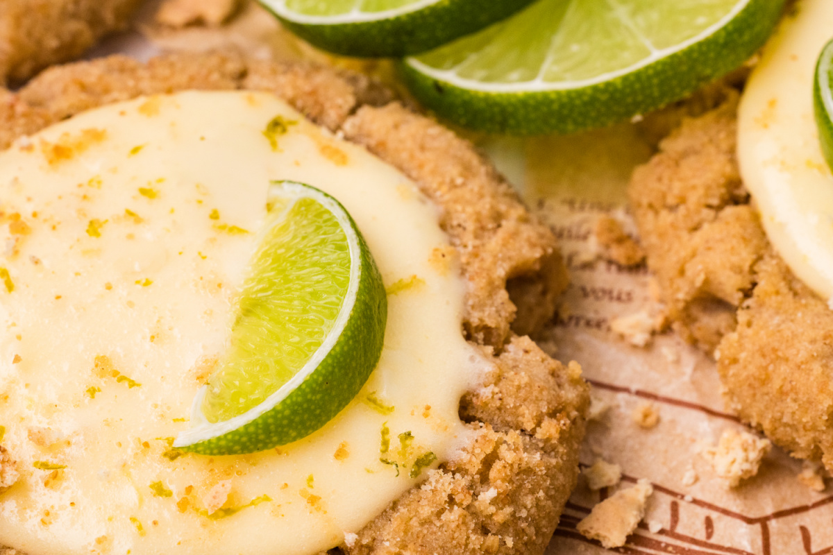 close-up of lime curd filling inside graham cracker cookie graham cracker cookie with creamy lime curd filling and fresh lime slice garnish