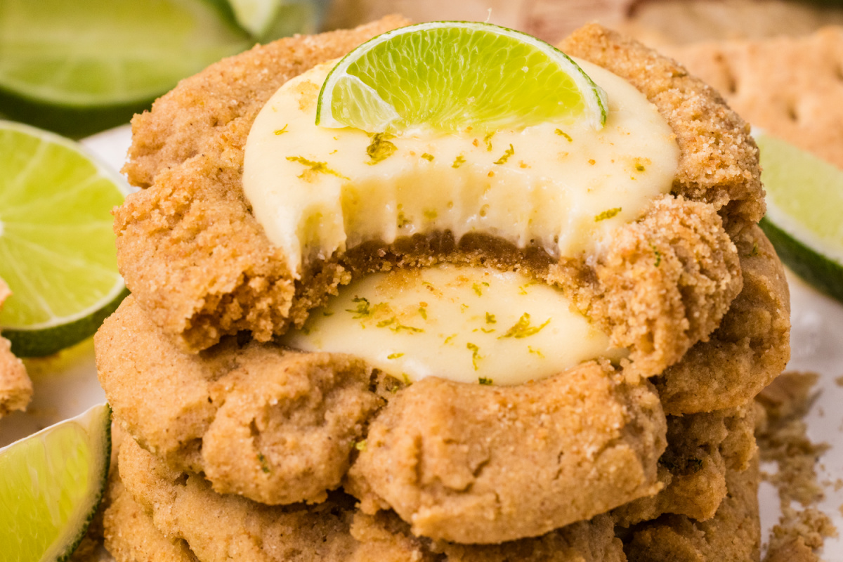 stacked cookies showing creamy lime center and crumb texture stacked graham cracker cookies filled with creamy lime curd and topped with fresh lime slice