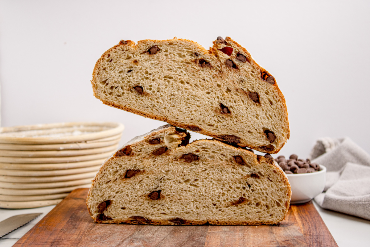 Inside view of the loaf with chocolate chips spread through the bread Chocolate Chip Artisan Bread cut in half showing the interior crumb with chocolate chips throughout