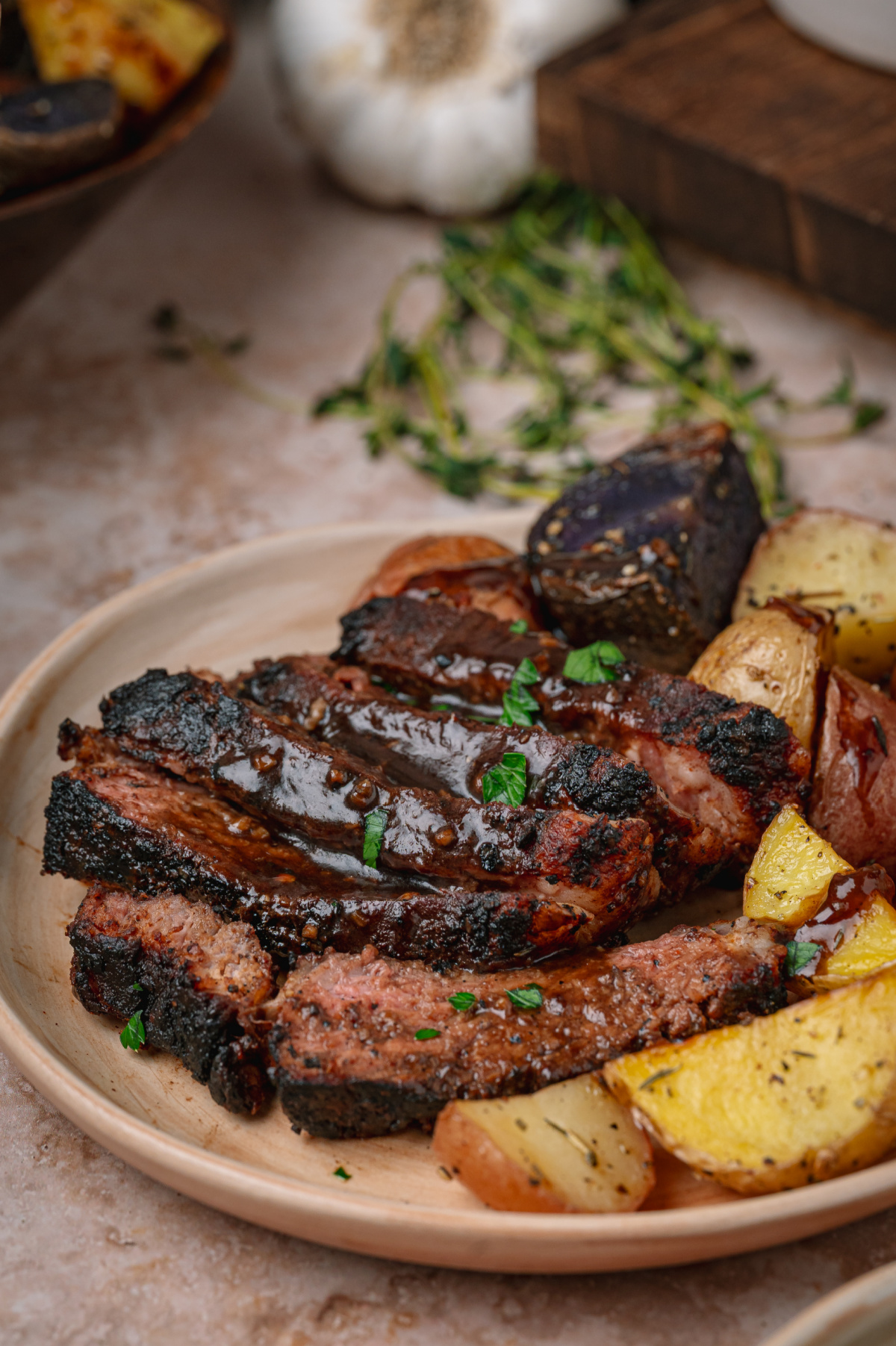 cocoa rubbed steak on a platter cocoa rubbed steak coated in dark stout pan sauce over roasted potatoes.