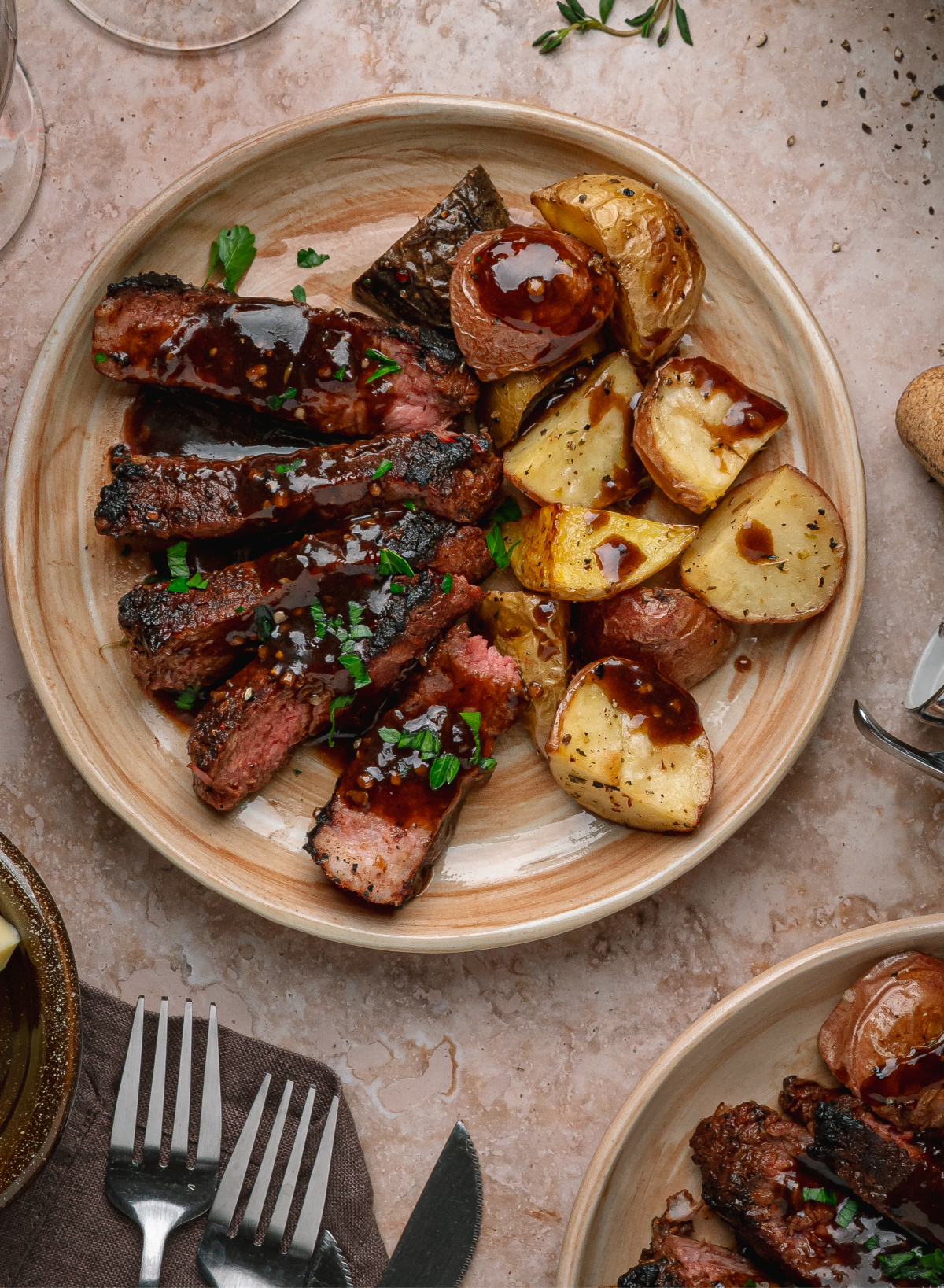 Cocoa crusted steak with roasted potatoes and stout sauce. Cocoa rubbed steak served with roasted potatoes and dark stout pan sauce on a dinner plate.