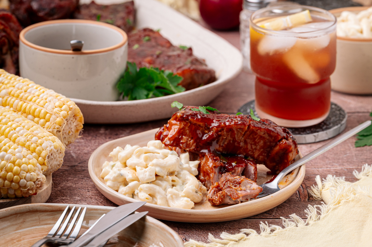 Bourbon peach country style ribs served with macaroni salad and corn on the cob