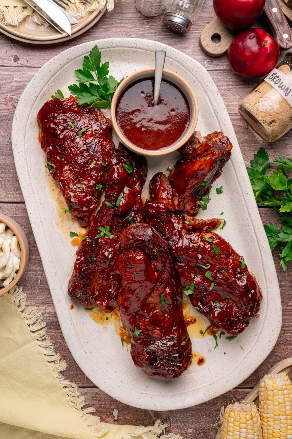Bourbon peach country style ribs glazed with peach bourbon barbecue sauce on a serving platter with extra sauce on the side